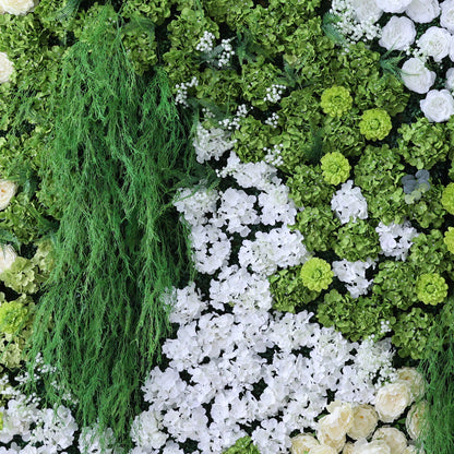 This image showcases a lush artificial floral wall. It features a dense arrangement of various green foliage, including trailing vines, alongside abundant white flowers like hydrangeas and small accent blooms. The combination creates a vibrant, natural - looking display with a harmonious blend of green and white, exuding freshness and elegance. Perfect for decorative purposes in events or as an interior backdrop, it blends artistry with a touch of nature&