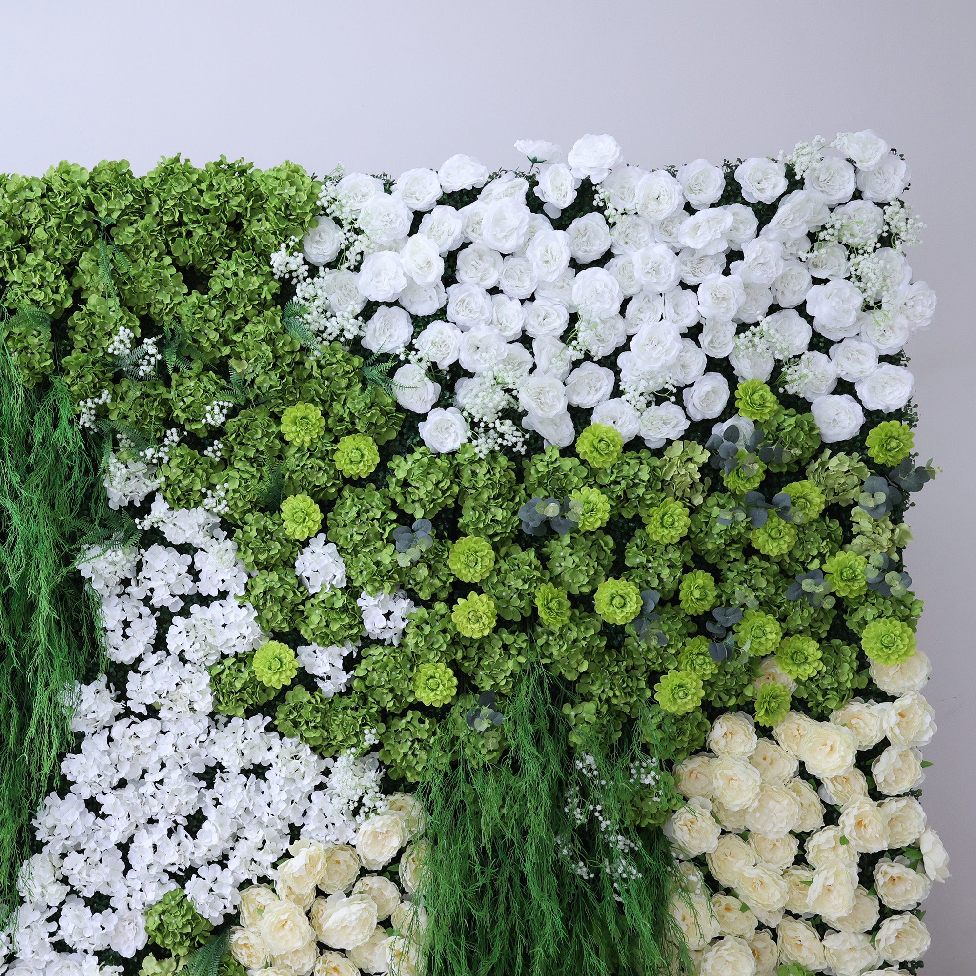 This image showcases a lush artificial floral wall. It features a dense arrangement of various flowers, including abundant white roses, creamy - hued blooms, and assorted white and green foliage. Trailing green vines add a natural touch. The harmonious blend of white, cream, and green creates a vibrant, elegant, and refreshing display, perfect for decorative purposes in events or as an interior backdrop, exuding a sense of natural beauty and artistry.