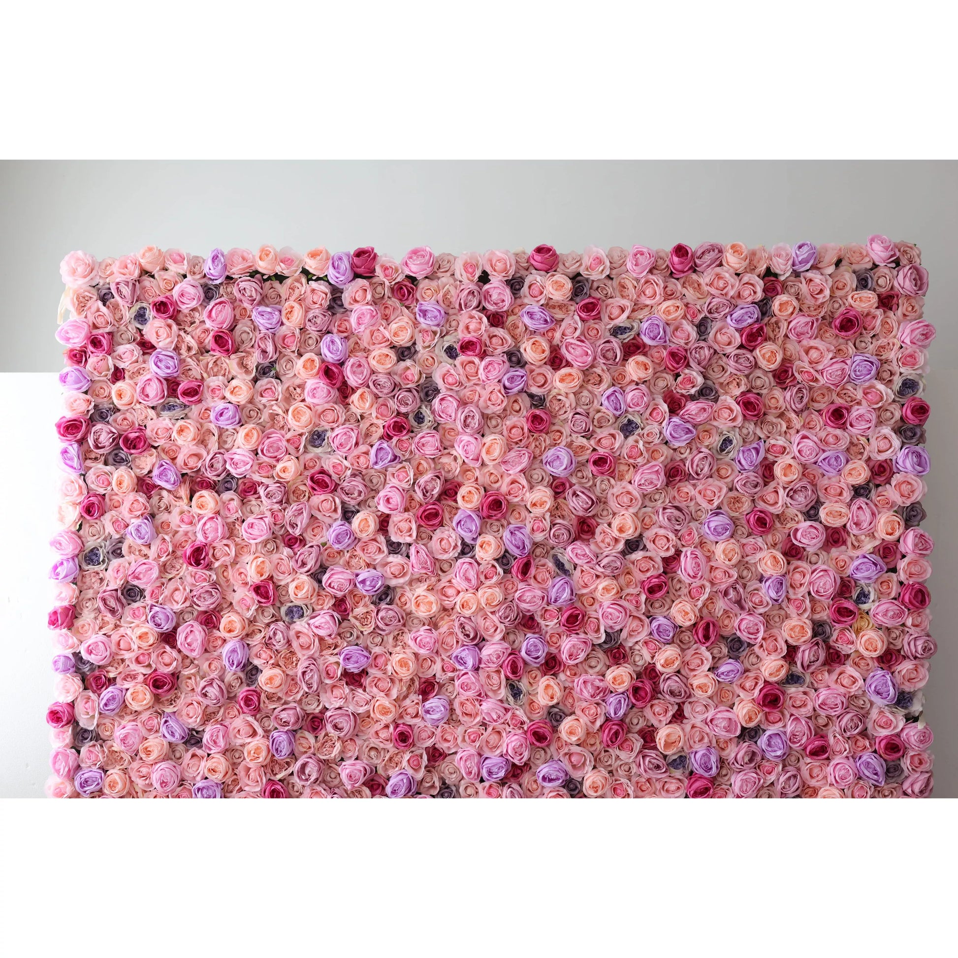 This large artificial flower wall showcases a dense, vibrant arrangement of roses in soft pink, peach, purple, and red. The harmonious color blend creates a lush, romantic texture, exuding elegance. Perfect as an event backdrop, it brings a dreamy, charming atmosphere with its intricate floral design. 