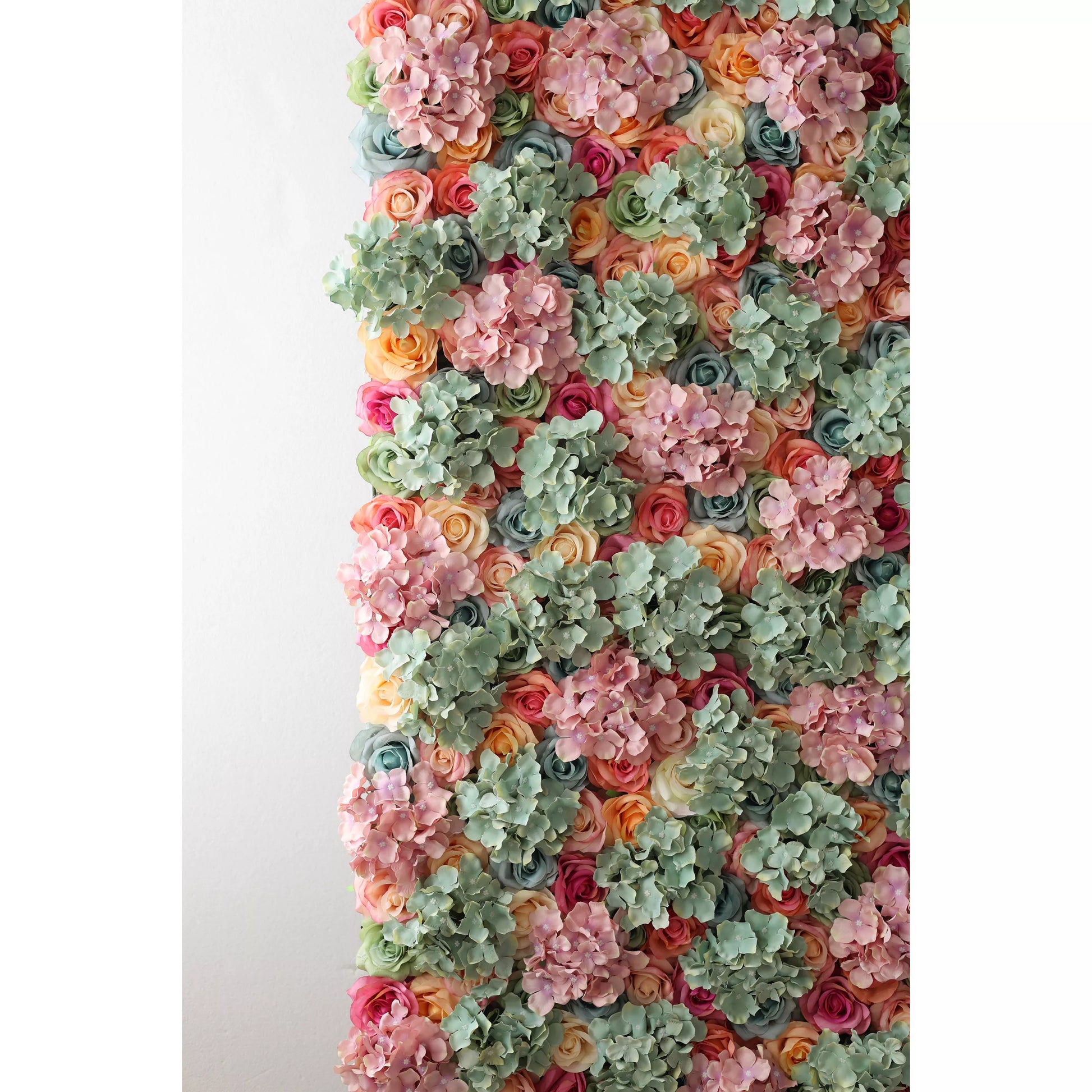 This is a large artificial flower wall, a vibrant tapestry of colors. It has soft pink hydrangeas, mint - green foliage, and roses in shades of peach, coral, red, and blue. The dense, varied arrangement creates a lush, textured display, evoking natural beauty. Perfect as a backdrop for events like weddings, it adds an elegant, romantic touch, enhancing the decorative appeal with its intricate floral design. 