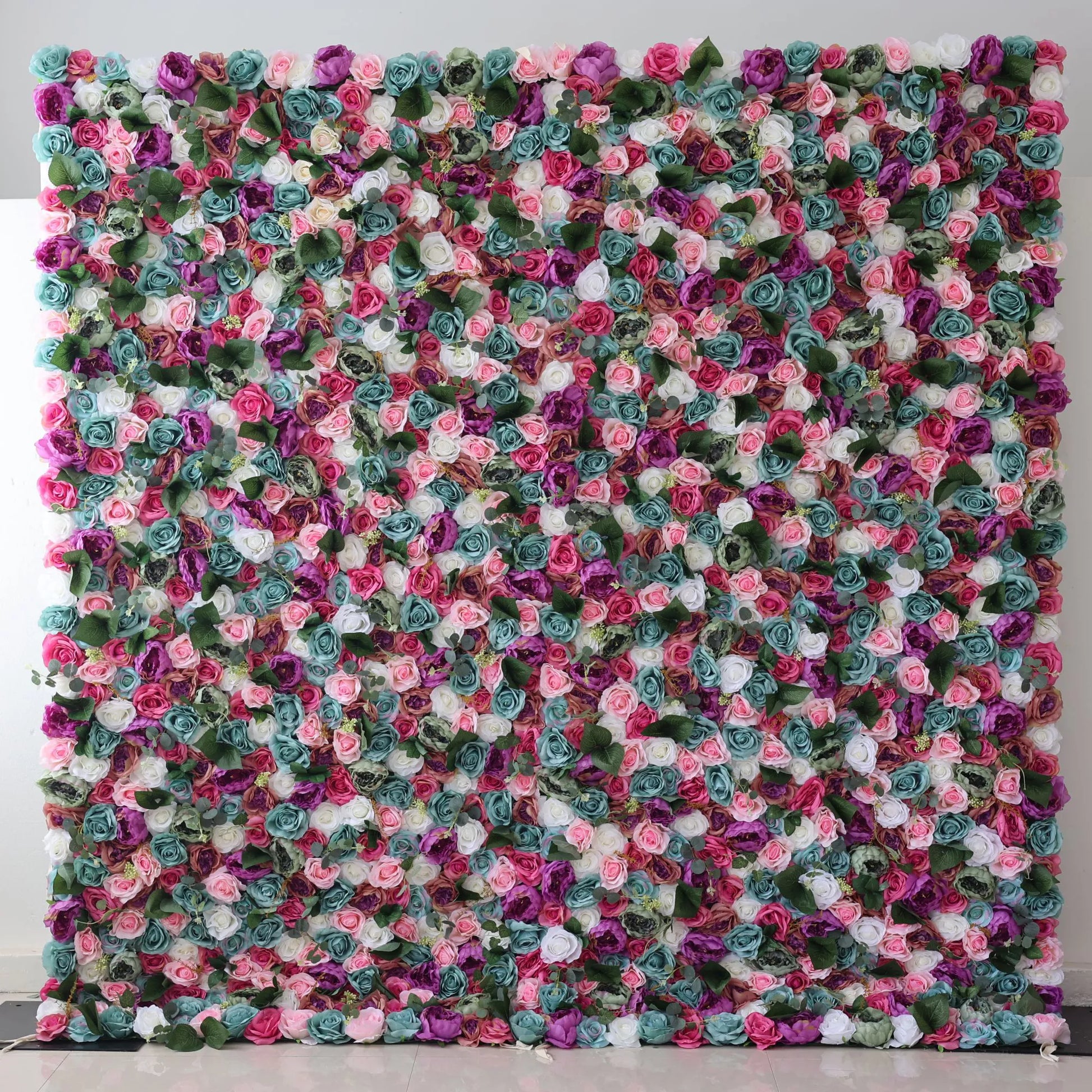 Valar Flowers Presents: This large artificial flower wall is a vibrant tapestry of colors. It features an array of roses in shades of pink, purple, white, teal, and more, interspersed with green foliage. The dense, intricate arrangement creates a lush, eye - catching display, perfect for adding a romantic, decorative touch to events or spaces. 
