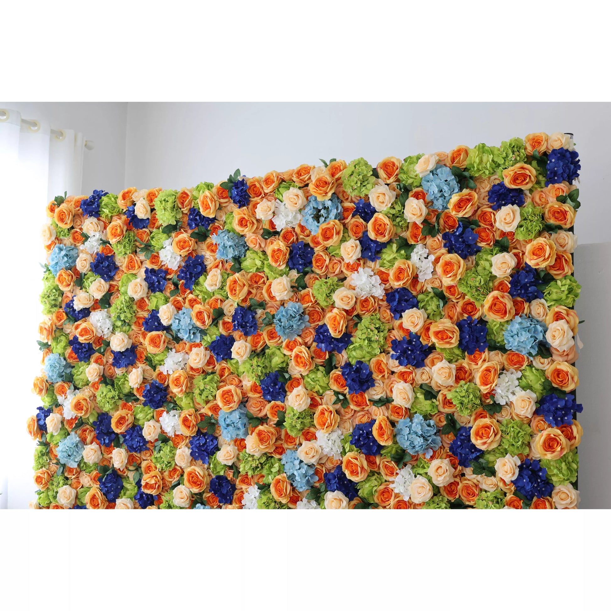 This large artificial flower wall is a vibrant display. It features orange roses, blue hydrangeas, white blooms, and green foliage, densely arranged for a lush, textured look. The colorful mix creates a cheerful, lively vibe, ideal as a backdrop for events like weddings or parties, adding an eye - catching, decorative charm. 