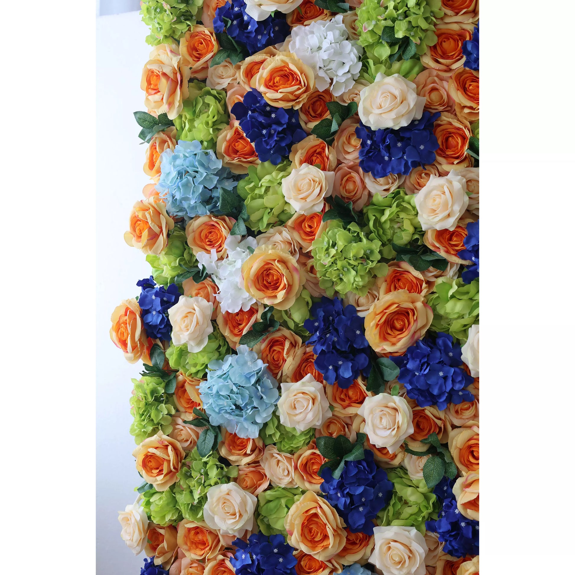 This vibrant artificial flower wall showcases a beautiful mix of orange roses, blue hydrangeas, cream - colored roses, and green foliage. The dense arrangement creates a lush, textured display, exuding a cheerful and lively charm. Perfect for event backdrops, it adds an eye - catching, decorative touch with its harmonious color palette. 