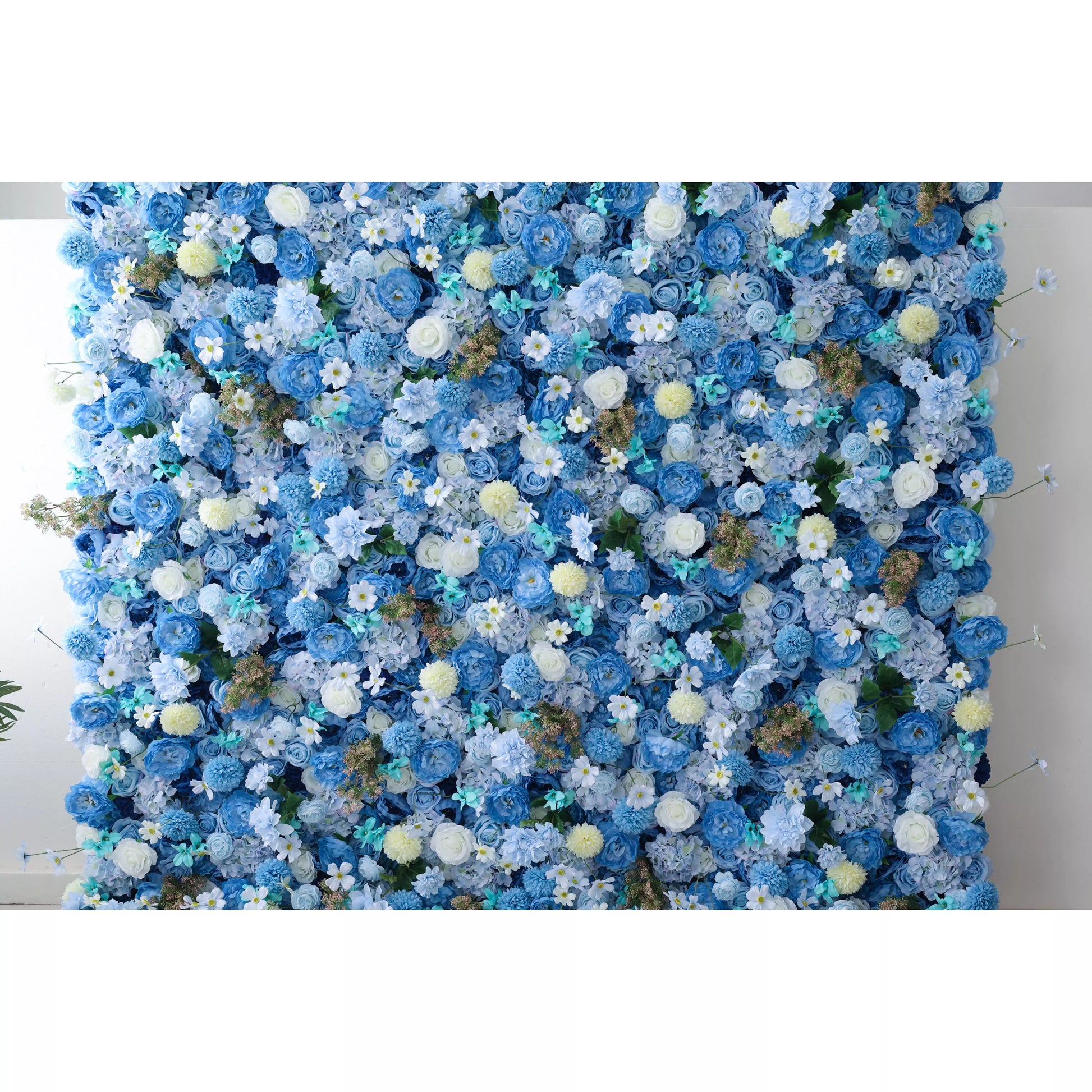 A large artificial flower wall showcases a lush blend of blue roses, delicate white flowers, and soft - yellow pom - poms, interspersed with teal foliage. The dense, varied blooms create a harmonious, elegant tapestry, evoking a serene, sophisticated vibe—perfect for adding a decorative, dreamy touch to events or spaces. 