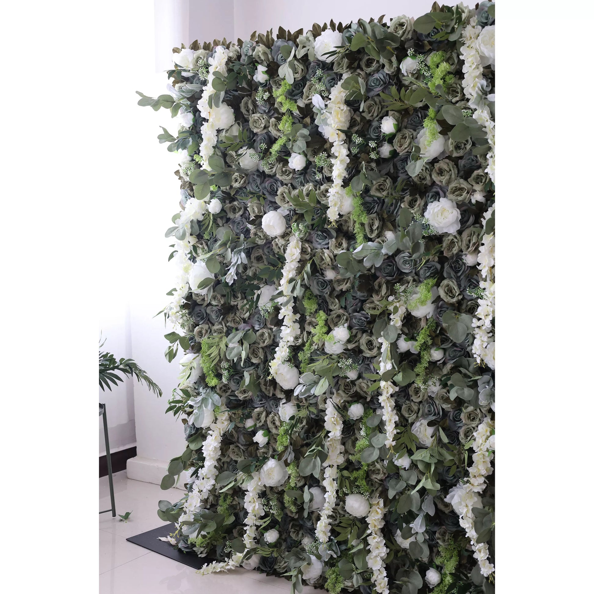 This large artificial flower wall features a lush mix of dark green roses, white blooms, trailing white flowers, and green foliage. The dense, layered arrangement creates a natural - looking, elegant backdrop, perfect for adding a touch of romance and sophistication to events or decor. 