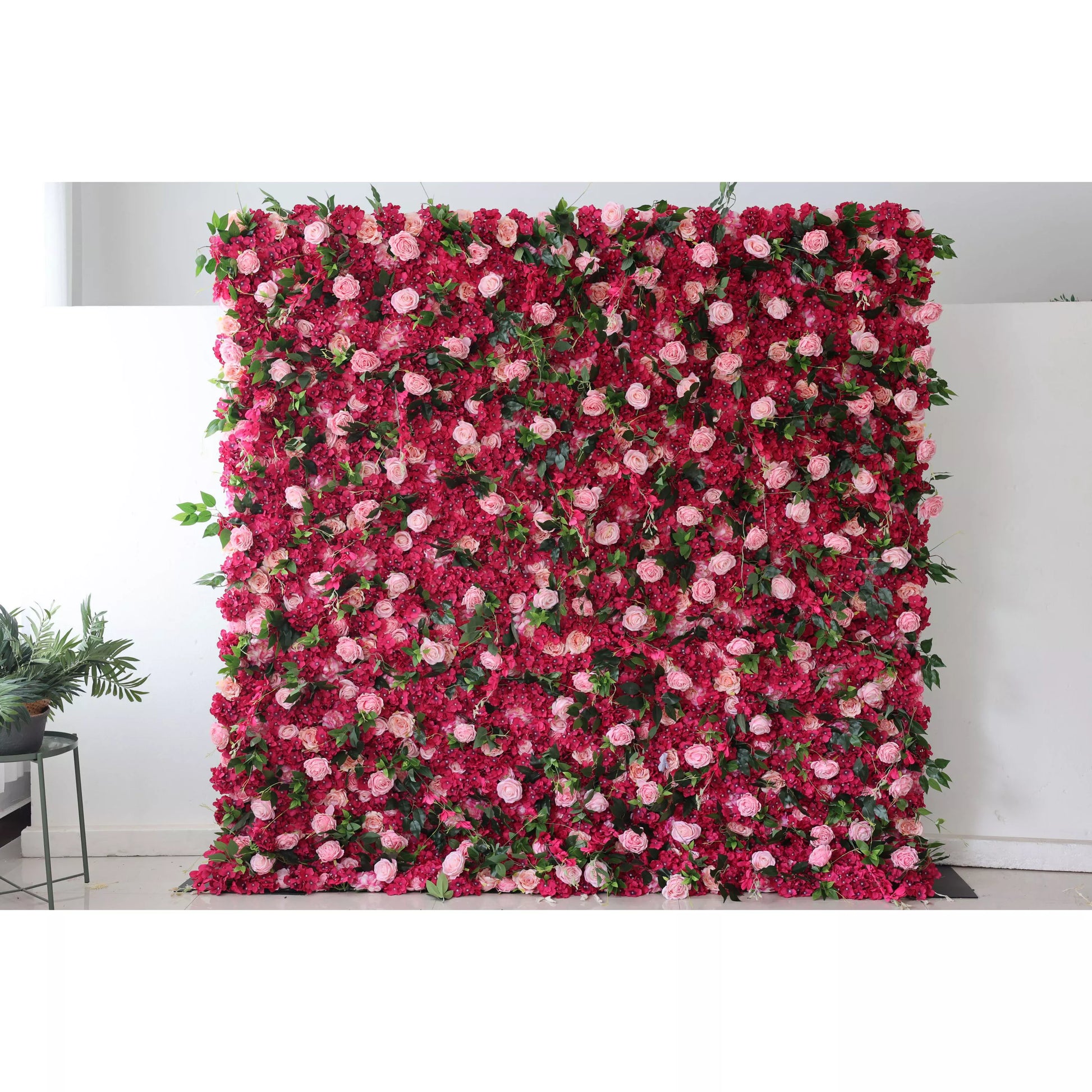 This is a large artificial flower wall. It combines deep - red blossoms with soft - pink roses, interspersed with green leaves. The dense, lush arrangement creates a romantic and eye - catching display, perfect for event backdrops, adding an elegant touch to weddings or parties. 
