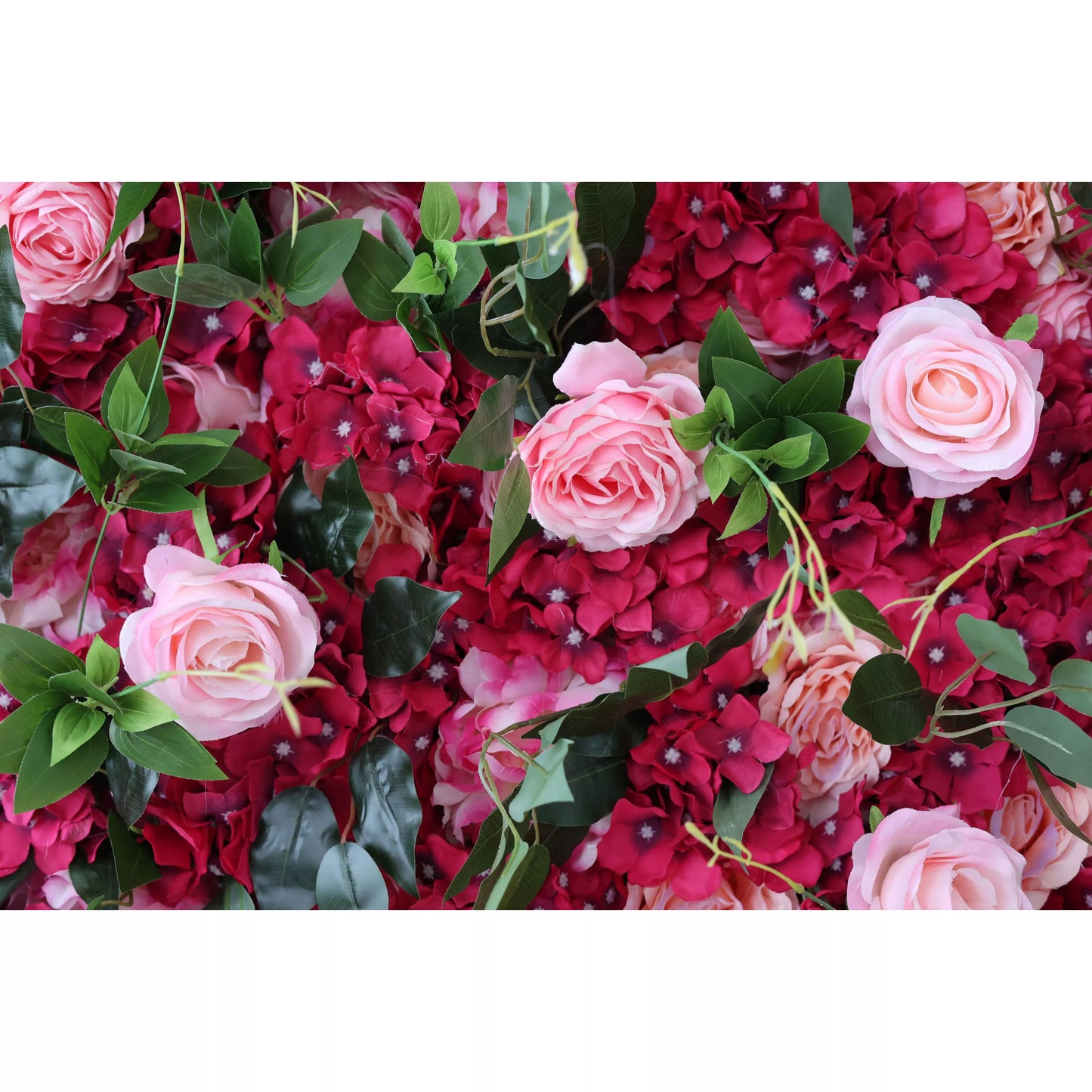 This close - up showcases a lush artificial flower wall. It features soft pink roses, deep red blossoms, and green leaves, creating a vibrant, romantic texture. The dense arrangement of varied blooms makes it an eye - catching backdrop, perfect for adding an elegant, decorative touch to events like weddings or parties. 
