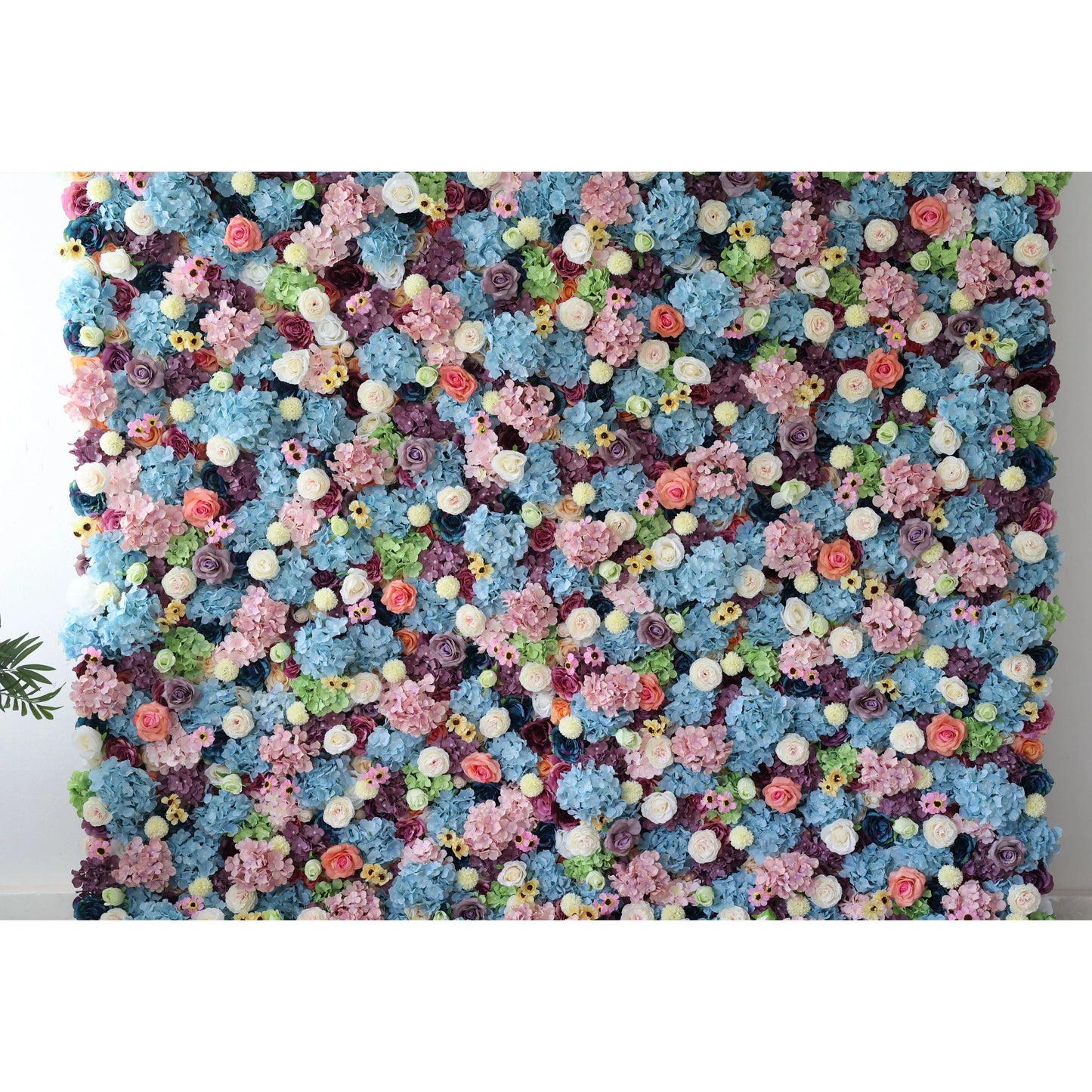 This is a large, vibrant artificial flower wall. It features a dense mix of blue hydrangeas, white roses, pink blossoms, yellow flowers, and green foliage. The colorful, lush arrangement creates a lively, eye - catching display, perfect for event backdrops, adding a cheerful and decorative touch to any space. 