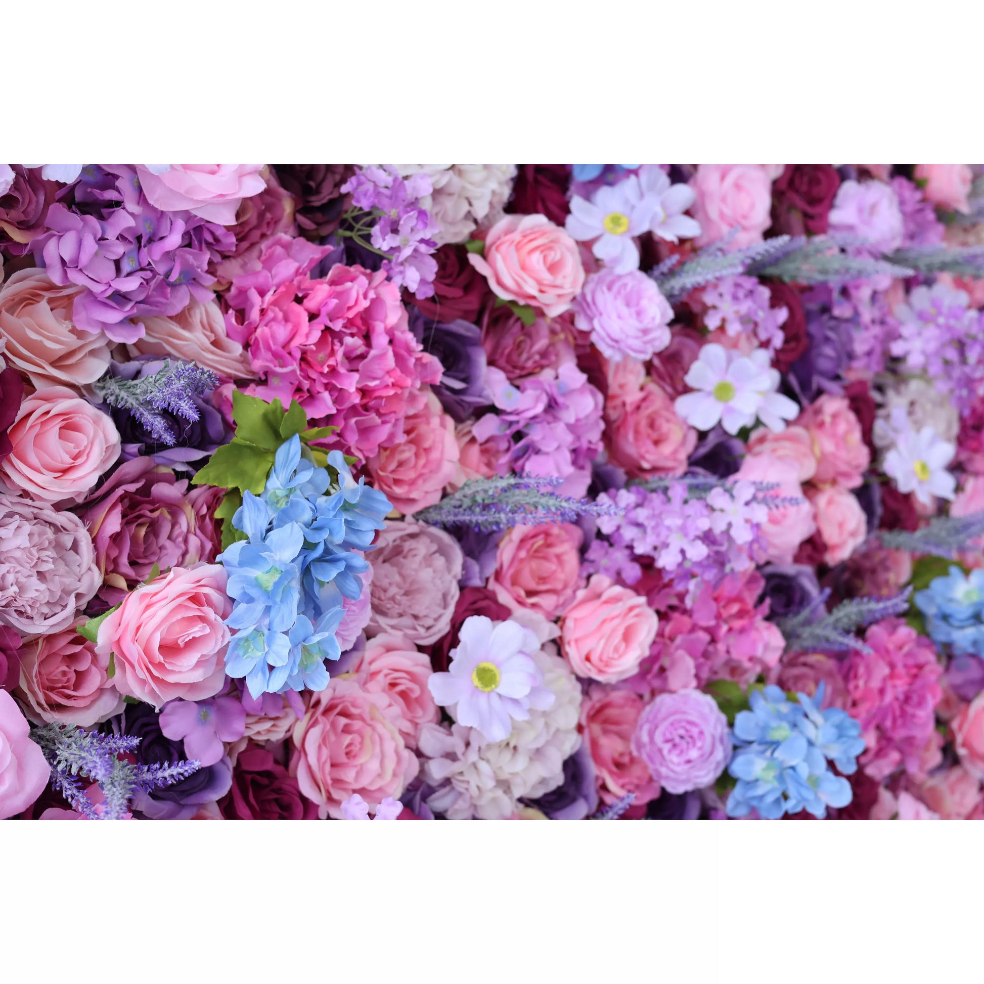 This is a close - up of a vibrant artificial flower wall. It blends pink roses, purple hydrangeas, blue blossoms, and white daisies. The dense, colorful arrangement creates a romantic, lush texture, perfect for decorative backdrops at weddings or events, exuding charm and elegance. 
