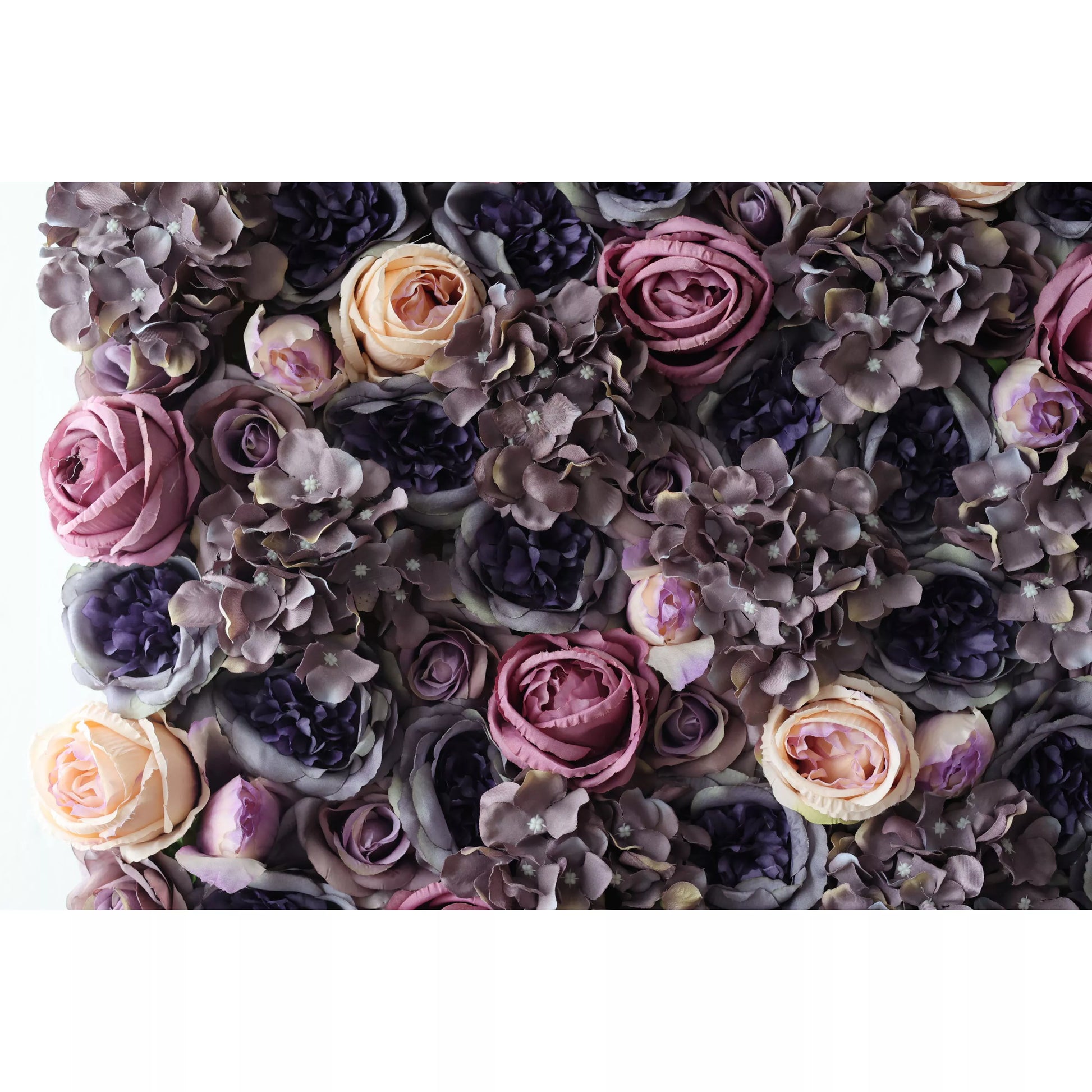 This flower wall is a luxurious display of artificial blooms. Rich hues of purple, lavender, and soft peach roses blend with dark hydrangeas, creating a dense, textured pattern. The moody color palette and intricate arrangement exude elegance, perfect for upscale events like weddings, adding a touch of sophistication and romance. 