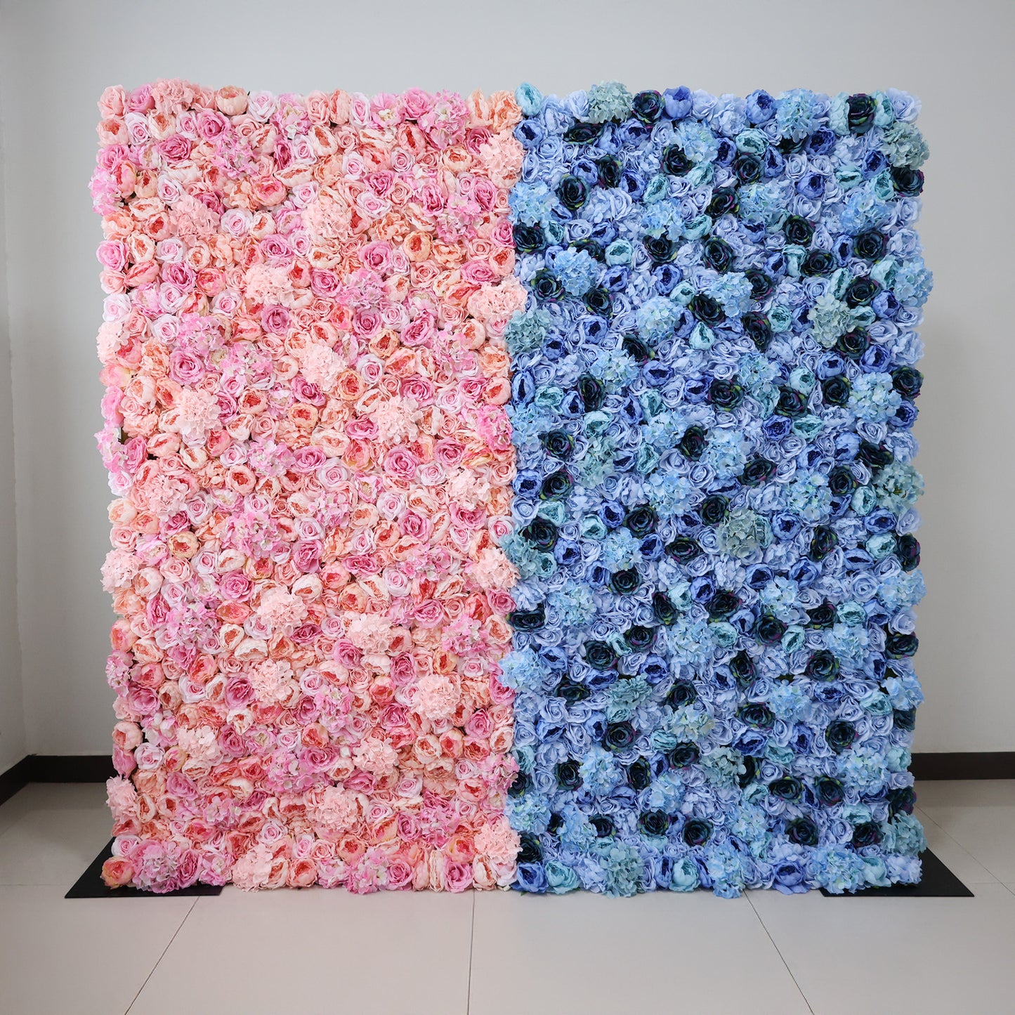This image showcases a stunning dual-toned floral backdrop by ValarFlowers, set indoors. It features dense arrangements of baby' shower artificial flowers—soft pinks and peaches on one side, and varied blues on the other. The lush, textured display exudes elegance, perfect for adding a luxurious, nature-inspired element to events or interiors.
