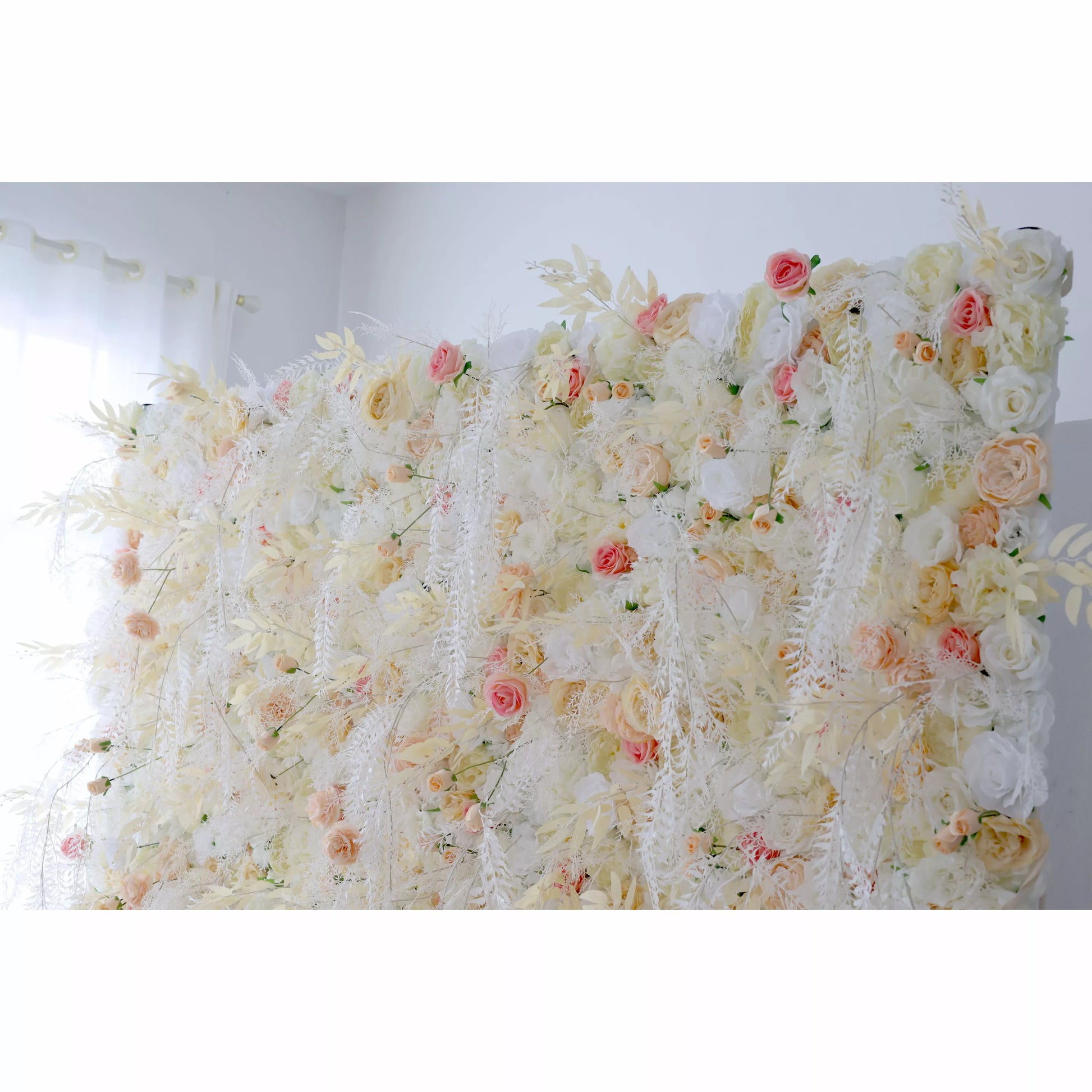 This flower wall is a dreamy mix of cream, white, and soft pink artificial blooms. It features roses, delicate flowers, and trailing white vines, creating an airy, romantic texture. Subtle color variations and lush greenery add depth, making it perfect for weddings or elegant events. It exudes an ethereal, whimsical vibe as a captivating backdrop. 