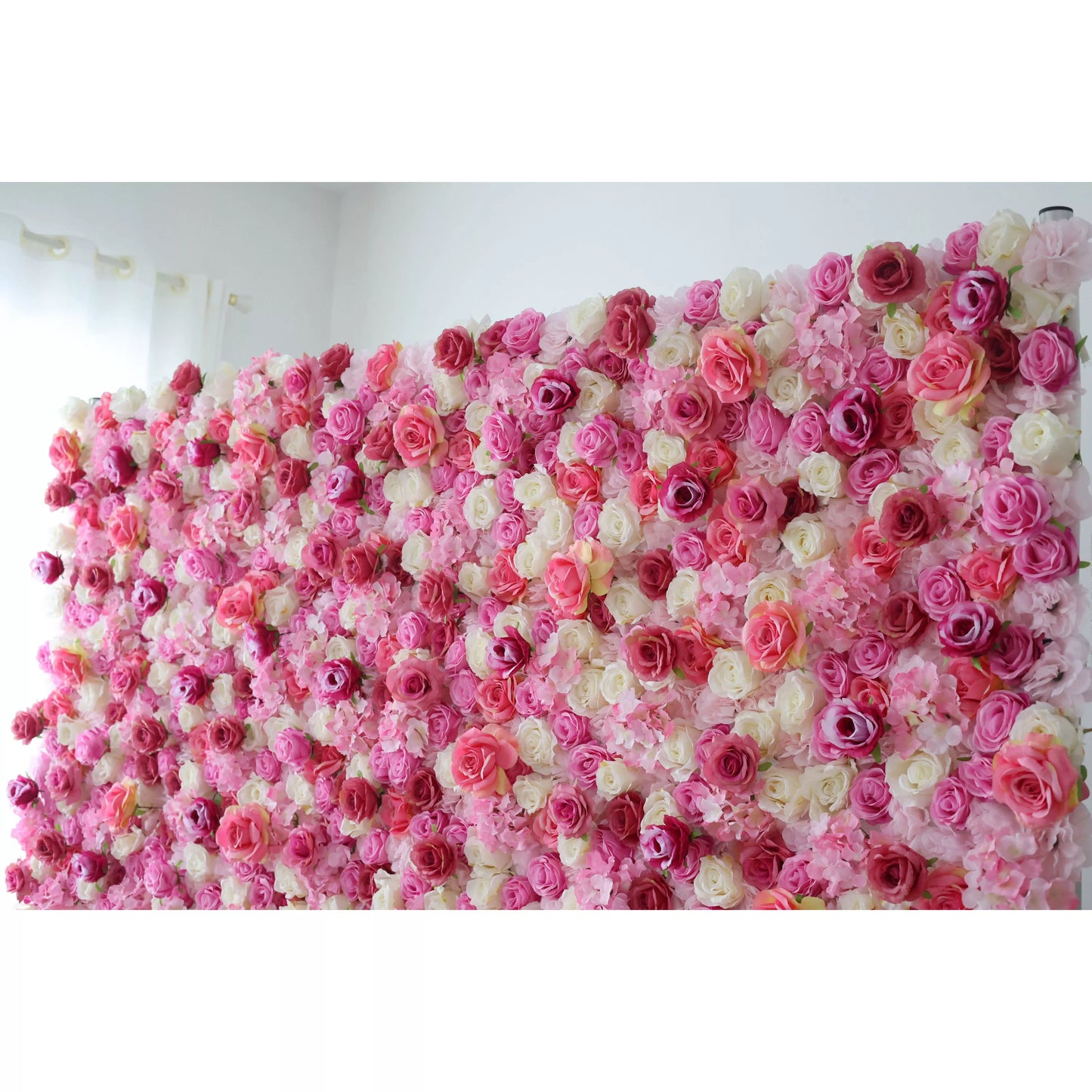 This flower wall is a vibrant tapestry of artificial roses in pink, white, and purple. Dense, overlapping blooms create a lush, romantic texture. Subtle color gradients and varied petal shapes add depth, making it perfect for weddings or events. It exudes elegance, offering a captivating backdrop for photos and decor. 
