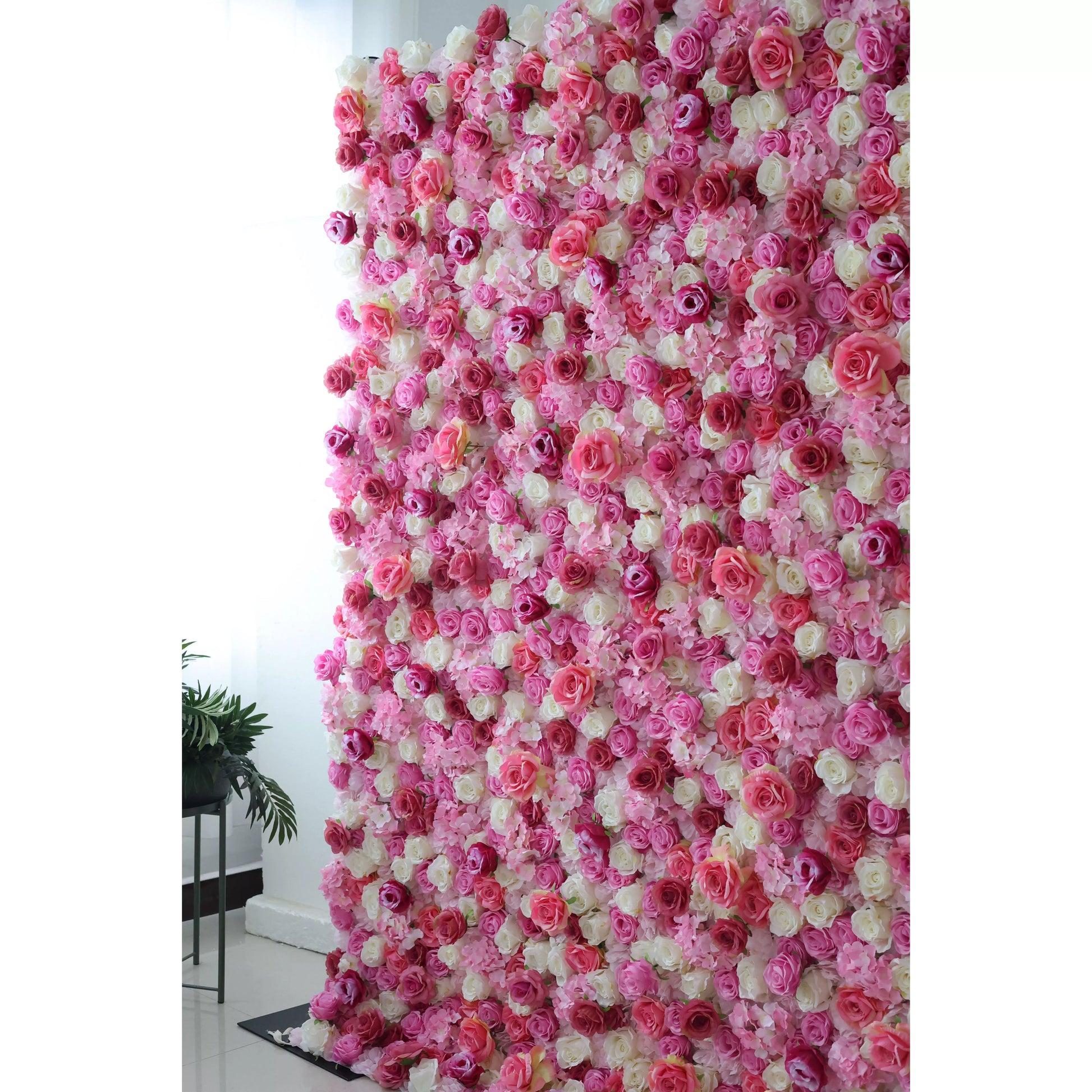 This flower wall is a stunning blend of pink, white, and purple artificial roses. Dense, overlapping blooms create a lush, romantic texture. Subtle color gradients and varied petal shapes add depth, making it perfect for weddings or events. It exudes elegance, offering a captivating backdrop for photos and decor. 