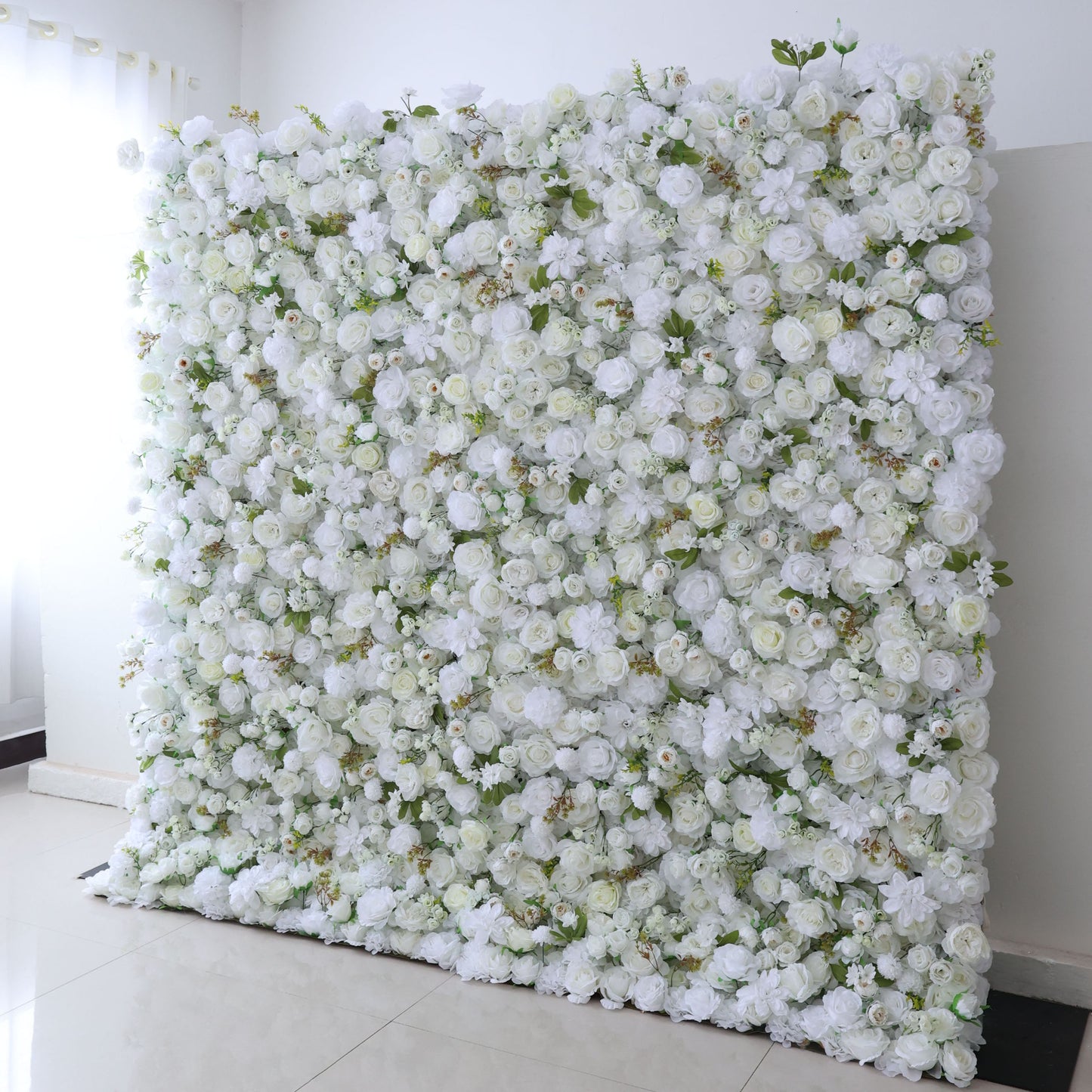 This backdrop, dominated by white artificial roses and other blooms with green leaves, features an all - white color scheme, looking clean and elegant. It's suitable for weddings, corporate events, bridal and baby showers, and fashion shows, adding an elegant touch to the occasion.