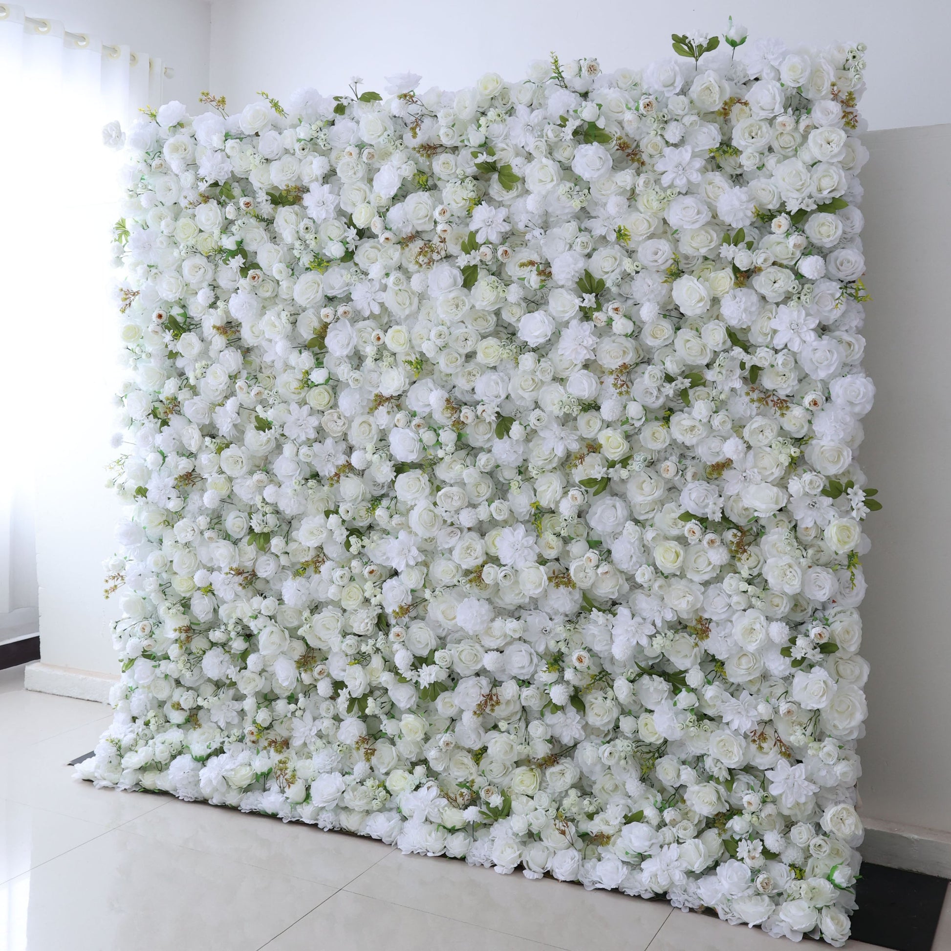 This backdrop, dominated by white artificial roses and other blooms with green leaves, features an all - white color scheme, looking clean and elegant. It's suitable for weddings, corporate events, bridal and baby showers, and fashion shows, adding an elegant touch to the occasion.