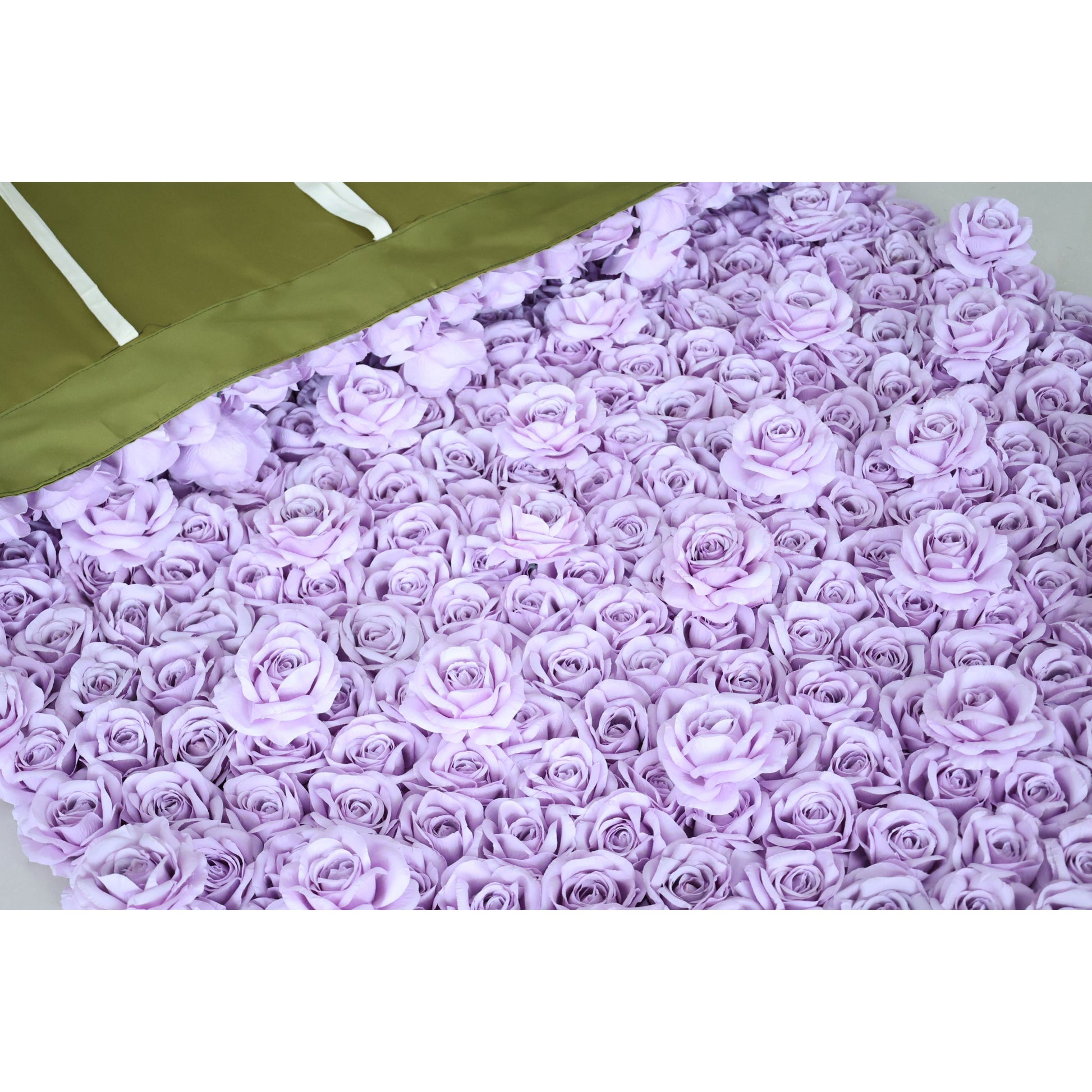 A close-up of a Valar Flowers lavender fabric rose panel, spread flat to showcase its ultra-dense, uniform 3D rose texture. The top corner reveals the olive-green backing with white hanging ribbons, highlighting the product’s durable construction and easy-install design—ideal for quick wedding, party, or photo booth decor setup.