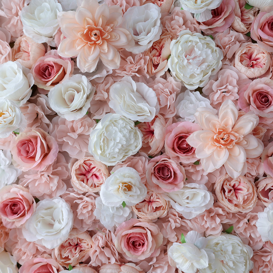 A dense arrangement of artificial flowers features a lovely mix of pink, peach, and white blooms. Various floral types, including roses and other delicate blossoms, create a lush, romantic display. The soft color palette gives an elegant, charming vibe, perfect for events like weddings or photo backdrops.