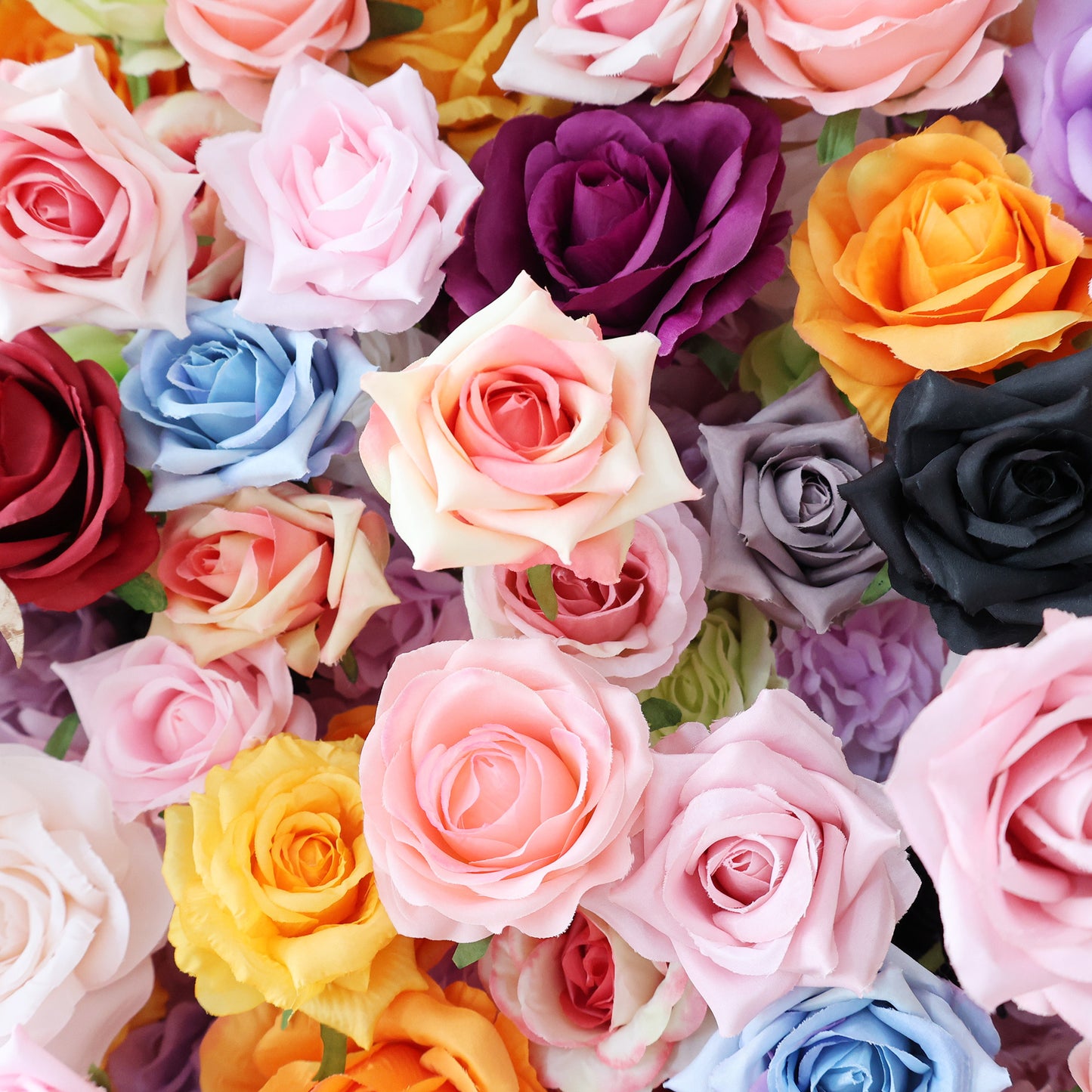 This close - up image showcases a dense arrangement of artificial roses in a vibrant array of colors. It includes shades like pink, purple, orange, blue, gray, black, yellow, and more. The roses, with their soft petals and varied hues, create a lush, colorful, and visually striking display, ideal for decorative purposes in events or as an attractive floral installation.