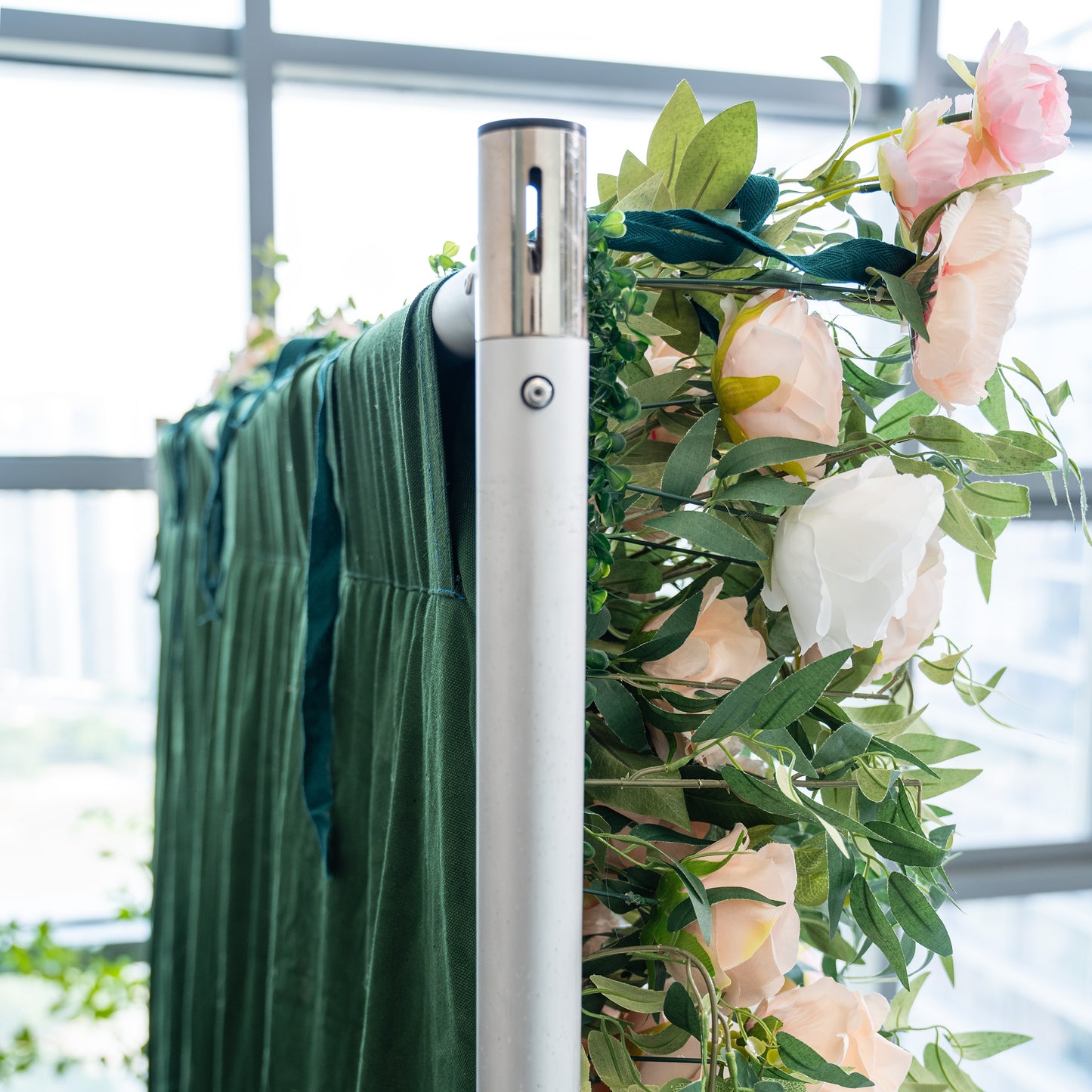 This photo captures a close - up of a floral arrangement featuring pink and white roses intertwined with green foliage, attached to a metallic structure draped with dark green fabric. Ideal for events such as a "Green and Gold Garden Gala" or a high - end corporate reception, it combines natural elegance with a touch of sophistication, making it a fitting decorative element for upscale indoor or outdoor occasions. 