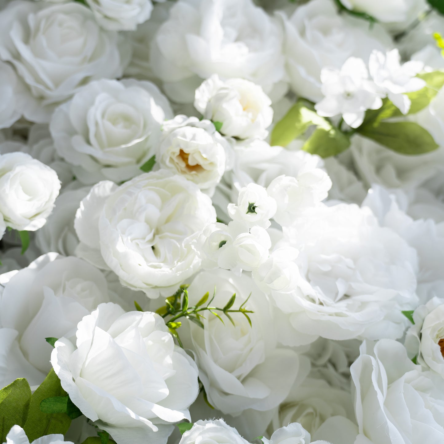 This close - up image features a lush arrangement of artificial white flowers, predominantly roses and some peony - like blooms. Interspersed with green leaves, the color palette is a pure white, exuding a sense of elegance and purity. The style is classic and sophisticated, making it ideal for formal events such as weddings or corporate functions. 