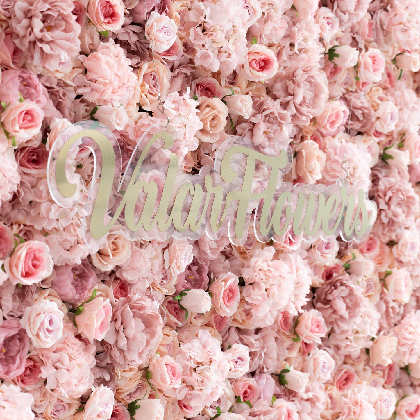 The lighting in this image appears to be soft, natural light. This type of lighting helps to highlight the delicate textures of the flowers without creating harsh shadows. It enhances the soft, romantic ambiance of the floral wall, making the petals' subtle details more visible.