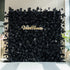 The image features a striking black floral wall with the name "ValarFlowers" prominently displayed in the center. The wall is adorned with black roses and feathers, creating a dramatic and elegant look.

