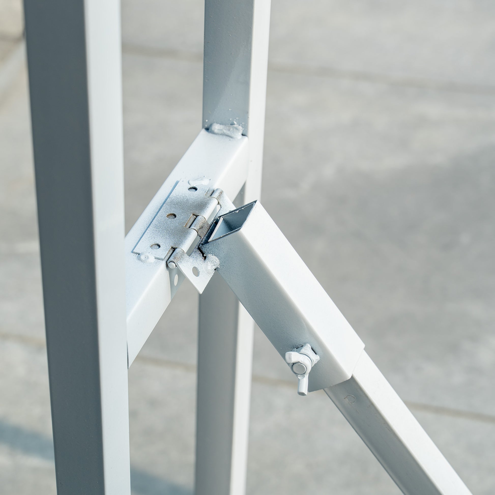 This backdrop stand is a metallic structure with a light - colored finish. It features a hinge mechanism, as seen in the image, which likely allows for folding or adjustment. The stand has a simple, sturdy design with a rectangular frame and diagonal support, secured with bolts and metal plates for stability. 