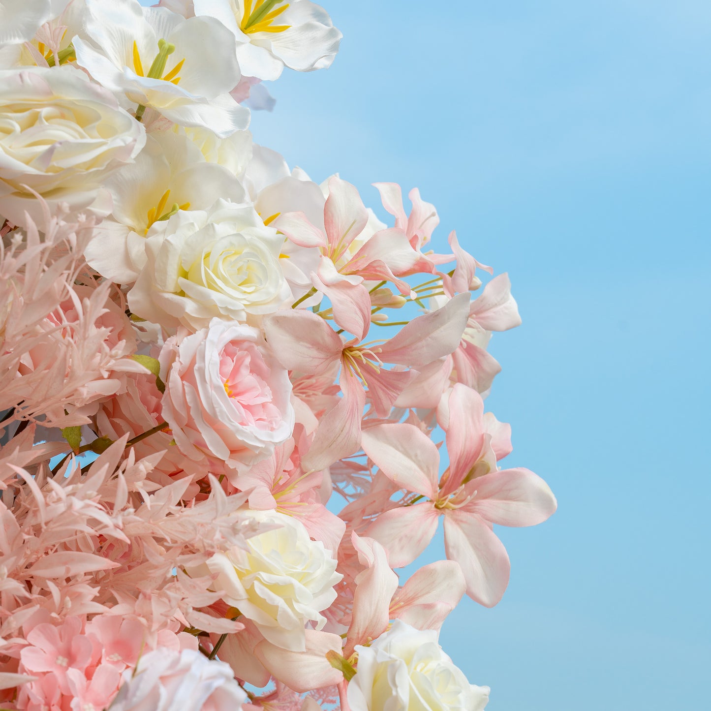 This floral arrangement showcases a mix of artificial flowers in soft hues. It includes white and pale - pink roses, delicate pink star - shaped flowers, and feathery pink foliage. The color palette is light and pastel, dominated by shades of pink and white, creating a romantic and dreamy style, perfect for wedding or bridal events. 