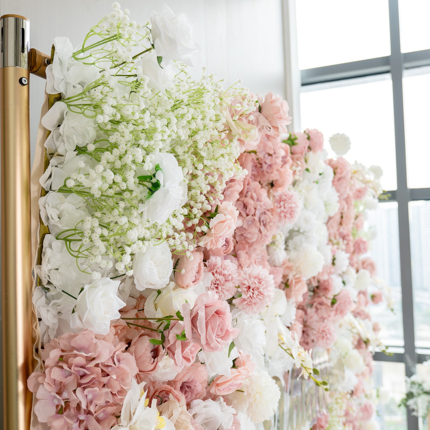 This backdrop is a lush floral arrangement supported by a golden - hued metal frame. It features a mix of artificial flowers including white roses, pink roses, white chrysanthemums, and clusters of baby's breath. The color palette combines soft pinks, pure whites, and touches of green, creating a romantic and elegant style, perfect for weddings or bridal events. 