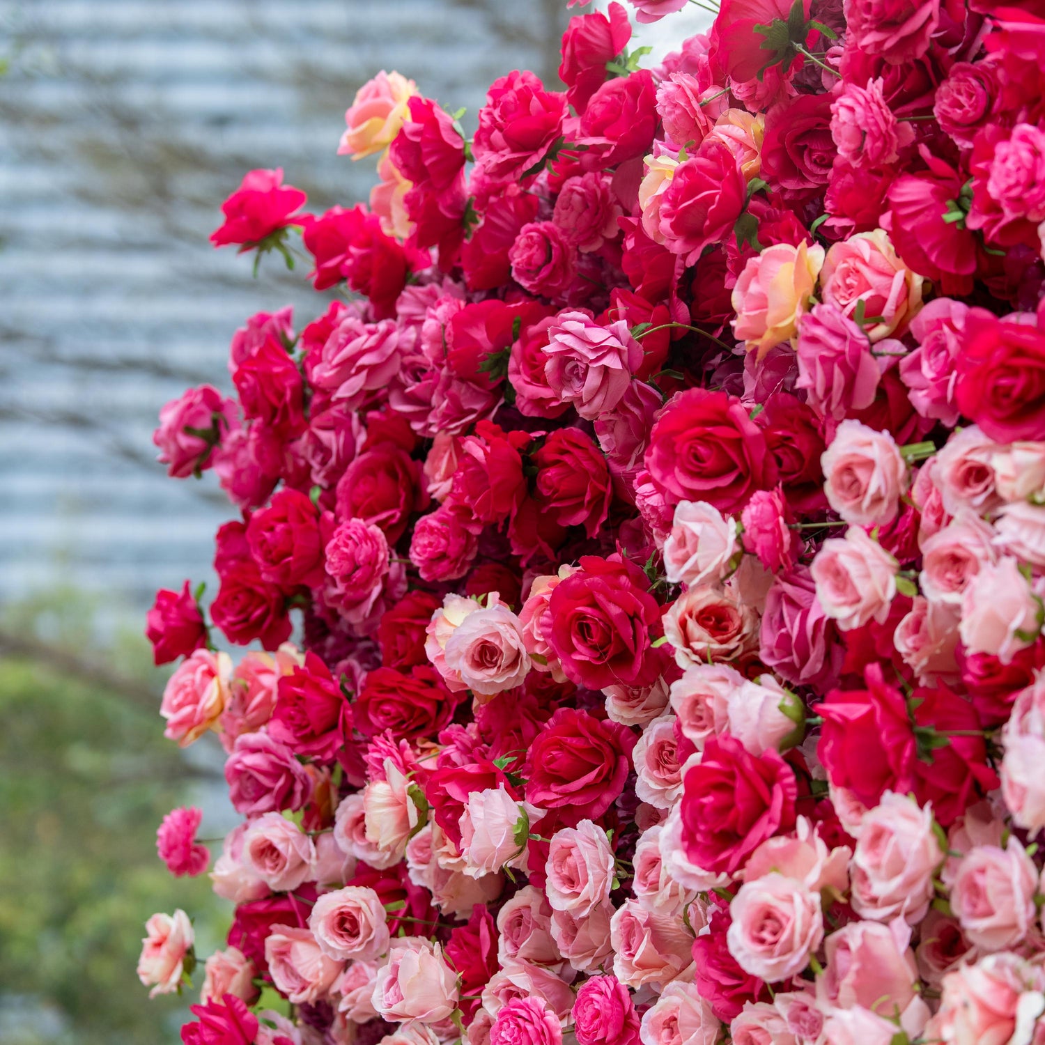 This backdrop is a lush expanse of artificial roses in a vivid blend of deep red and pink hues. The densely - packed blooms create a rich, romantic tapestry, exuding a luxurious and passionate atmosphere, perfect for weddings or upscale events. 