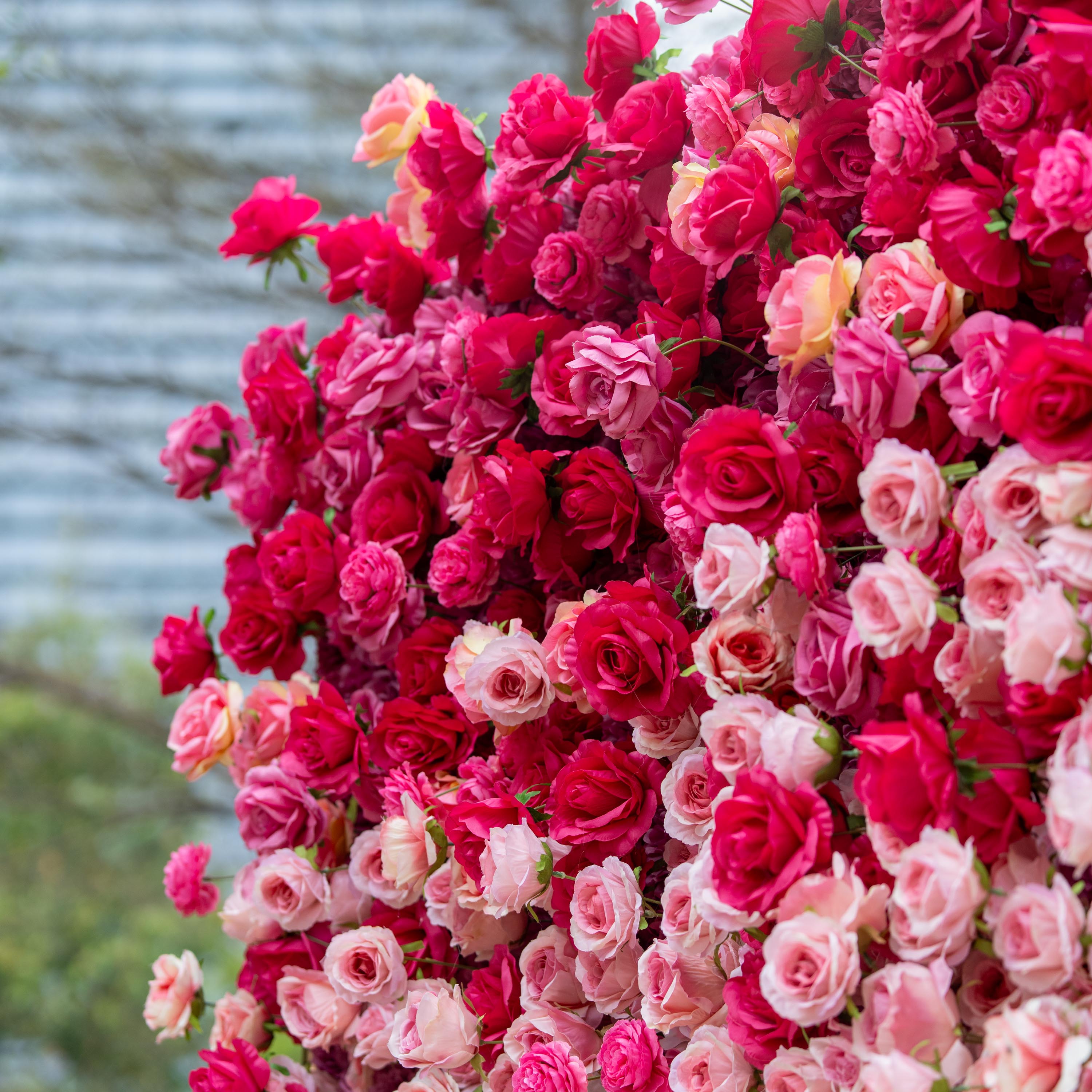 This backdrop is a lush expanse of artificial roses in a vivid blend of deep red and pink hues. The densely - packed blooms create a rich, romantic tapestry, exuding a luxurious and passionate atmosphere, perfect for weddings or upscale events. 
