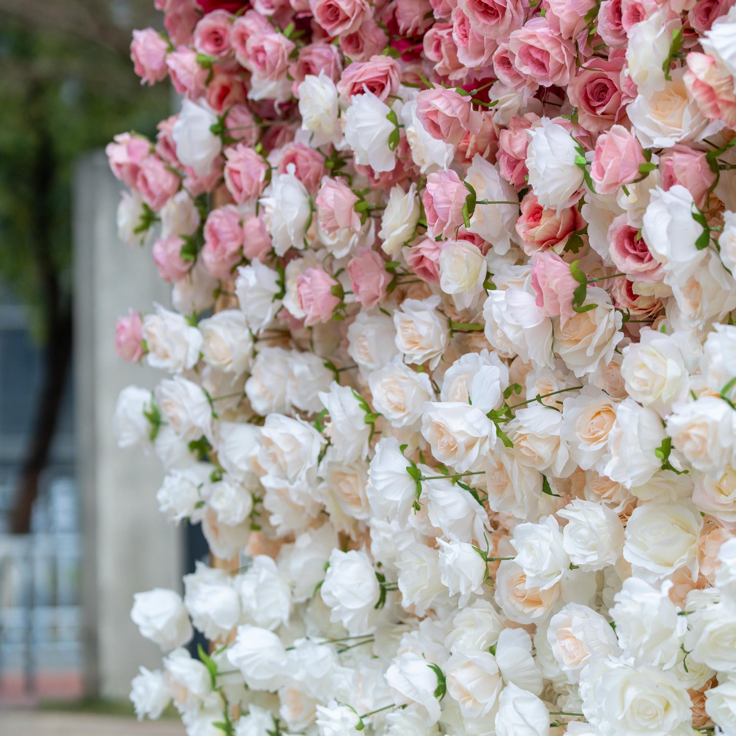 This backdrop showcases a dense, elegant arrangement of artificial roses in soft pink and white hues. The flowers are meticulously placed, creating a smooth color gradient that exudes a romantic and refined ambiance, perfect for weddings or upscale events. 