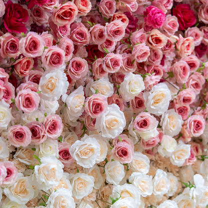 This backdrop features a dense, enchanting arrangement of artificial roses in a gradient of soft pink and white hues. The meticulously placed blooms create a romantic and elegant atmosphere, perfect for weddings or upscale events. 