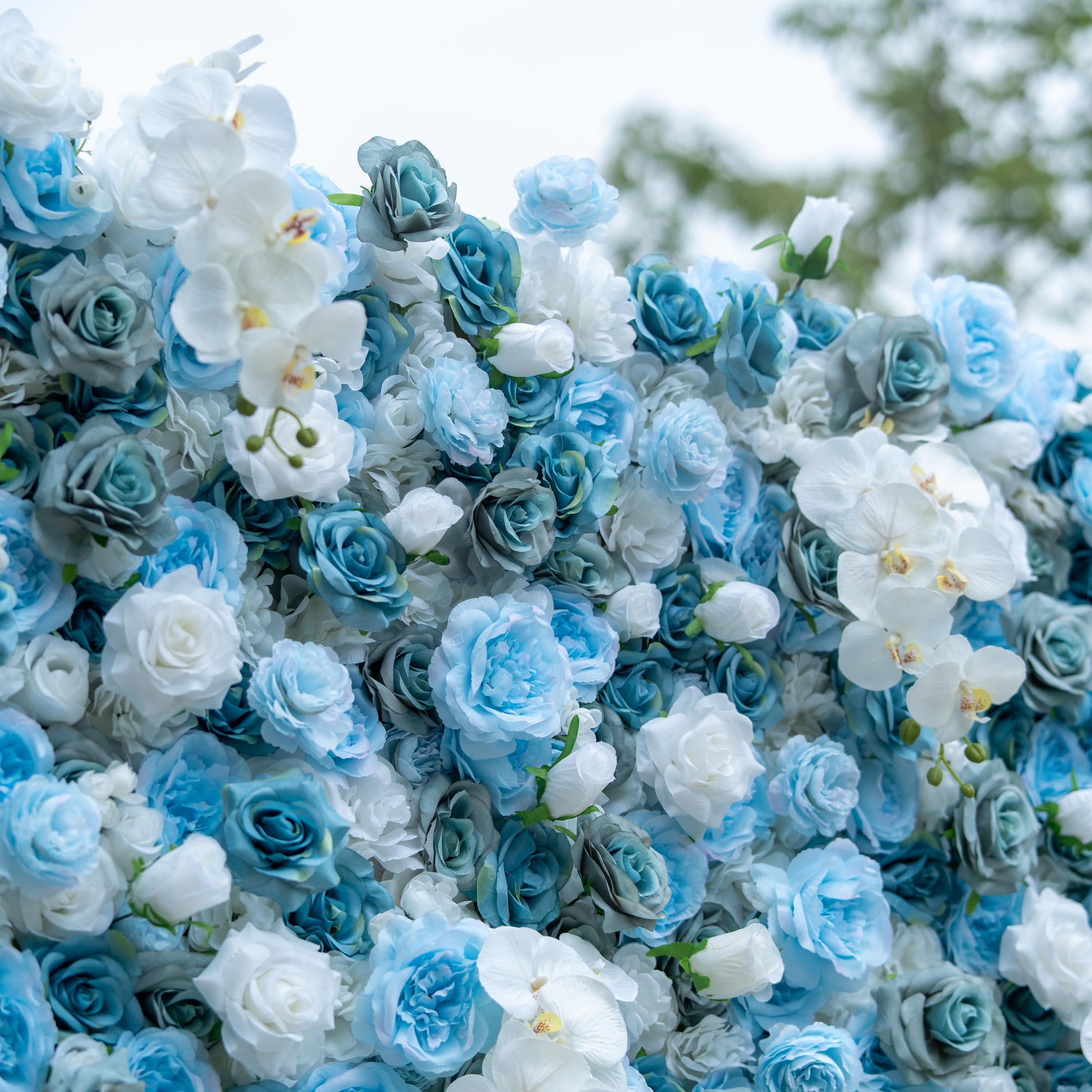 This photo features a dense floral arrangement combining blue and white roses with white orchids. The cool - toned palette creates a serene and refined look. Ideal for events like baby showers with a "Blue & White - A New Beginning" theme, or upscale corporate product launches aiming for a modern and tranquil aesthetic. It could also serve as a backdrop for a "Winter Wonderland" - themed wedding, evoking a sense of cool elegance and freshness. 