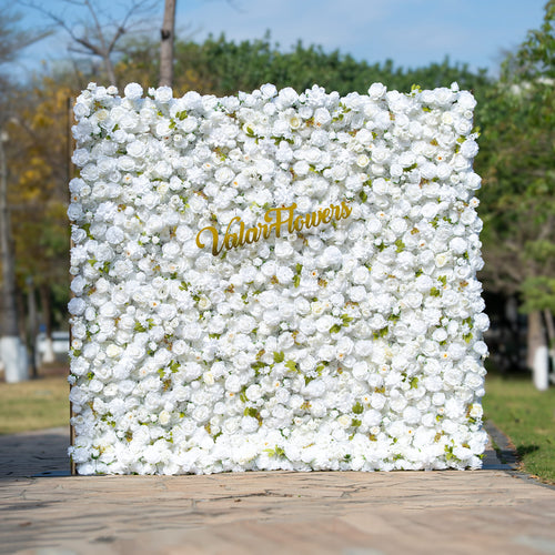 This floral backdrop is densely covered with artificial white roses, interspersed with small green leaves, creating a clean and pure look. The all - white color palette exudes a sense of elegance and simplicity. The golden “ValarFlowers” sign adds a touch of luxury. The overall style is classic and sophisticated, suitable for formal events like weddings or corporate functions. 