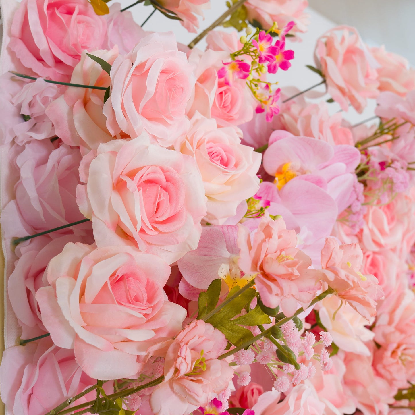 This backdrop features a charming arrangement of artificial flowers. Predominantly in soft pastel pink hues, it includes roses with their classic, layered petals, along with delicate pink orchids and small clusters of pink - hued filler flowers. 

The overall style is romantic and feminine, creating a warm and inviting atmosphere, perfect for events like weddings, bridal showers, or other celebratory gatherings. 