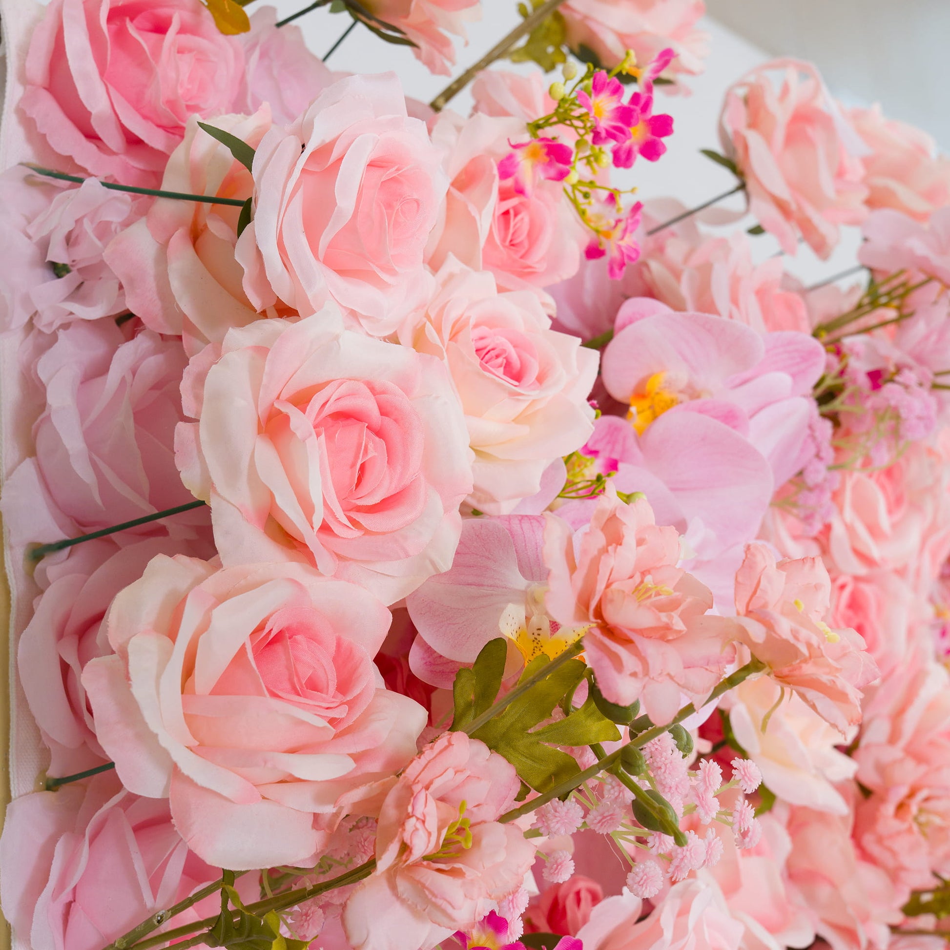 This backdrop features a charming arrangement of artificial flowers. Predominantly in soft pastel pink hues, it includes roses with their classic, layered petals, along with delicate pink orchids and small clusters of pink - hued filler flowers. 

The overall style is romantic and feminine, creating a warm and inviting atmosphere, perfect for events like weddings, bridal showers, or other celebratory gatherings. 