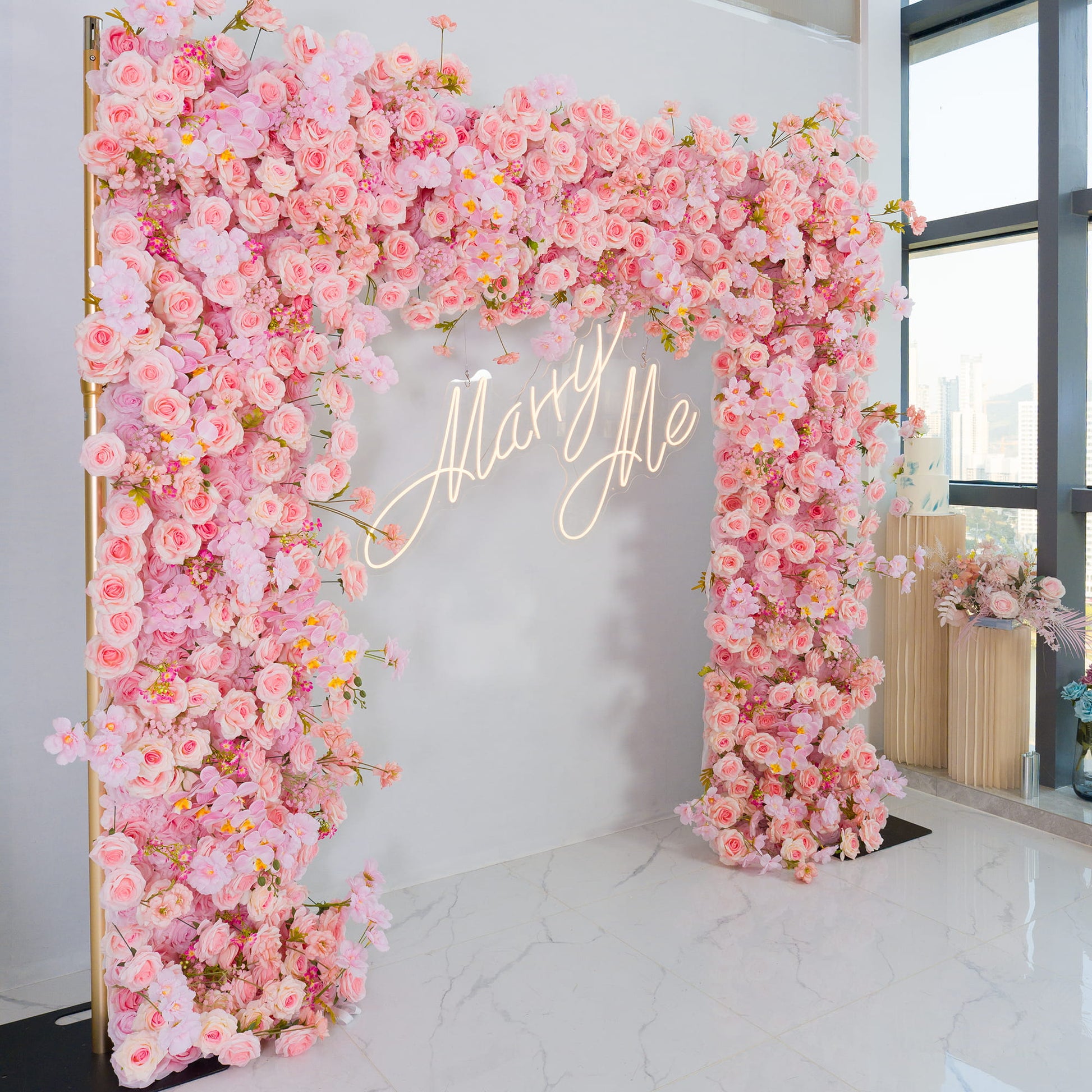 This backdrop is a stunning floral archway, densely adorned with artificial flowers. The main types include pink roses, delicate pink orchids, and other assorted pink blooms. The color scheme features a range of soft to medium - toned pinks, creating a warm and romantic atmosphere.

A prominent "Marry Me" neon sign in elegant script adds a touch of charm. The overall style is romantic and whimsical, perfect for proposals, weddings, or other romantic celebrations. 