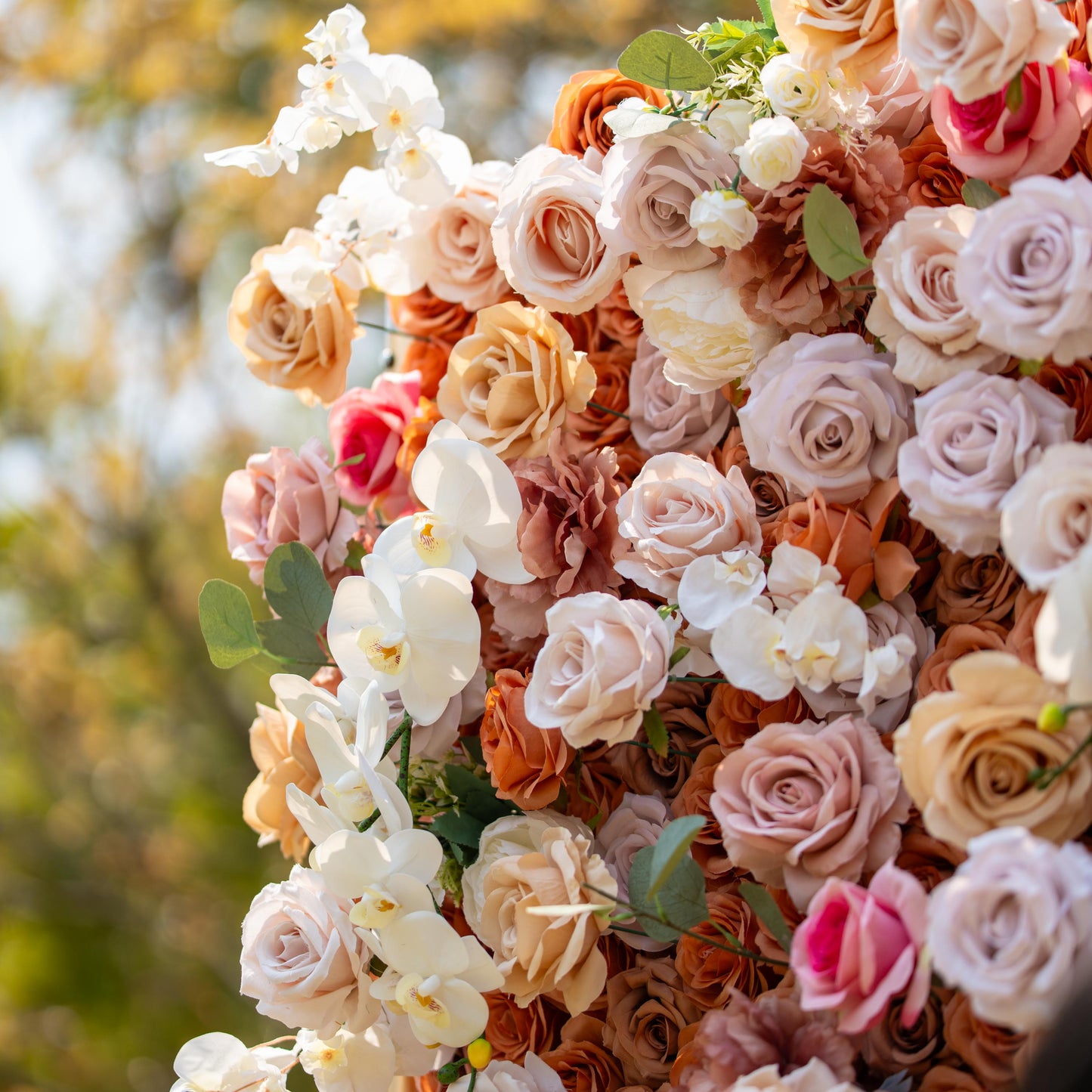 This backdrop features a warm, earthy theme with colors like beige, cream, and soft brown. It is densely adorned with roses and white orchids. Ideal for elegant events such as weddings, upscale garden parties, or refined corporate celebrations. 