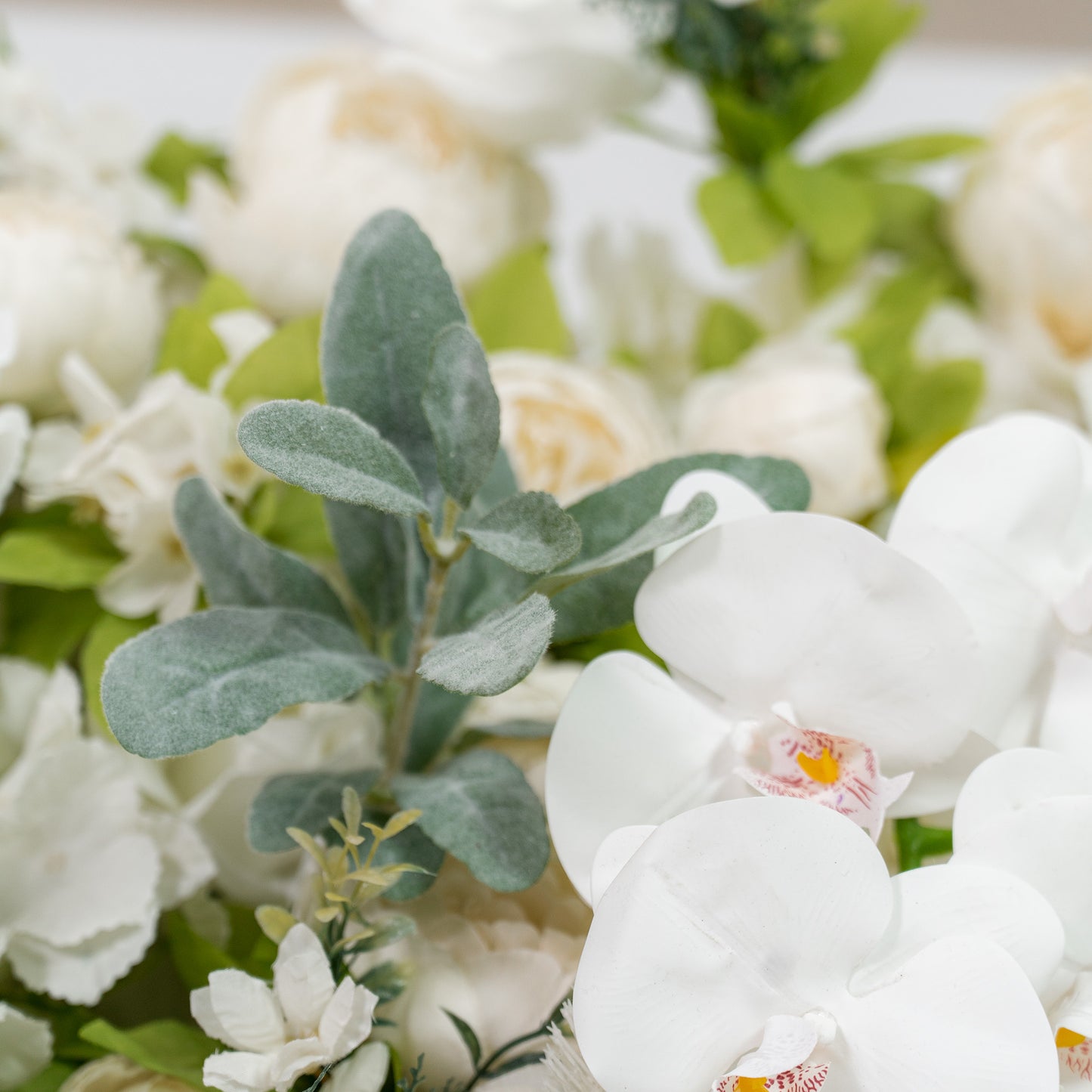 This backdrop features white orchids and assorted green foliage, with a soft, monochromatic white and green color theme. It exudes a refined and serene elegance, making it perfect for weddings, upscale parties, or formal events. 