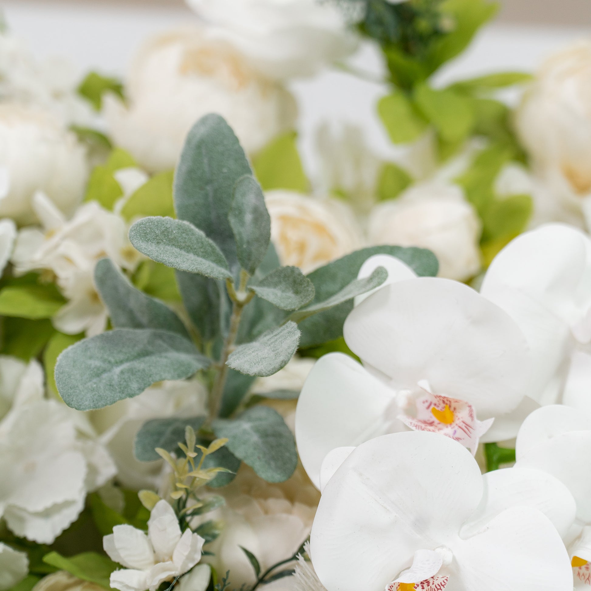 This backdrop features white orchids and assorted green foliage, with a soft, monochromatic white and green color theme. It exudes a refined and serene elegance, making it perfect for weddings, upscale parties, or formal events. 