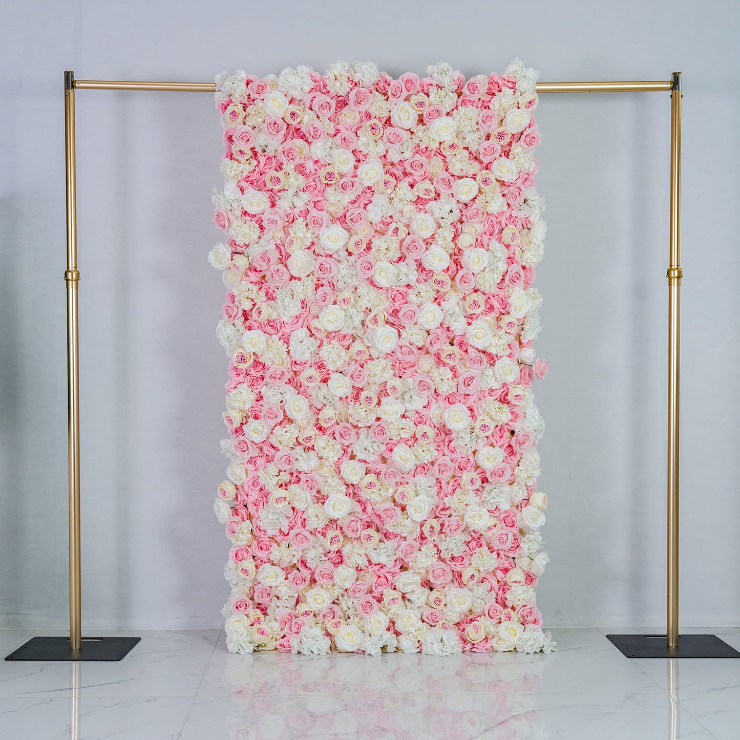 This photo features a large floral backdrop densely covered with pink and white roses, creating a soft and romantic color scheme. Mounted on a golden frame, it exudes elegance. Ideal for weddings, bridal showers, or other romantic events, its pastel hues and lush arrangement give a dreamy, sophisticated style. Size appears substantial, making a bold decorative statement. 