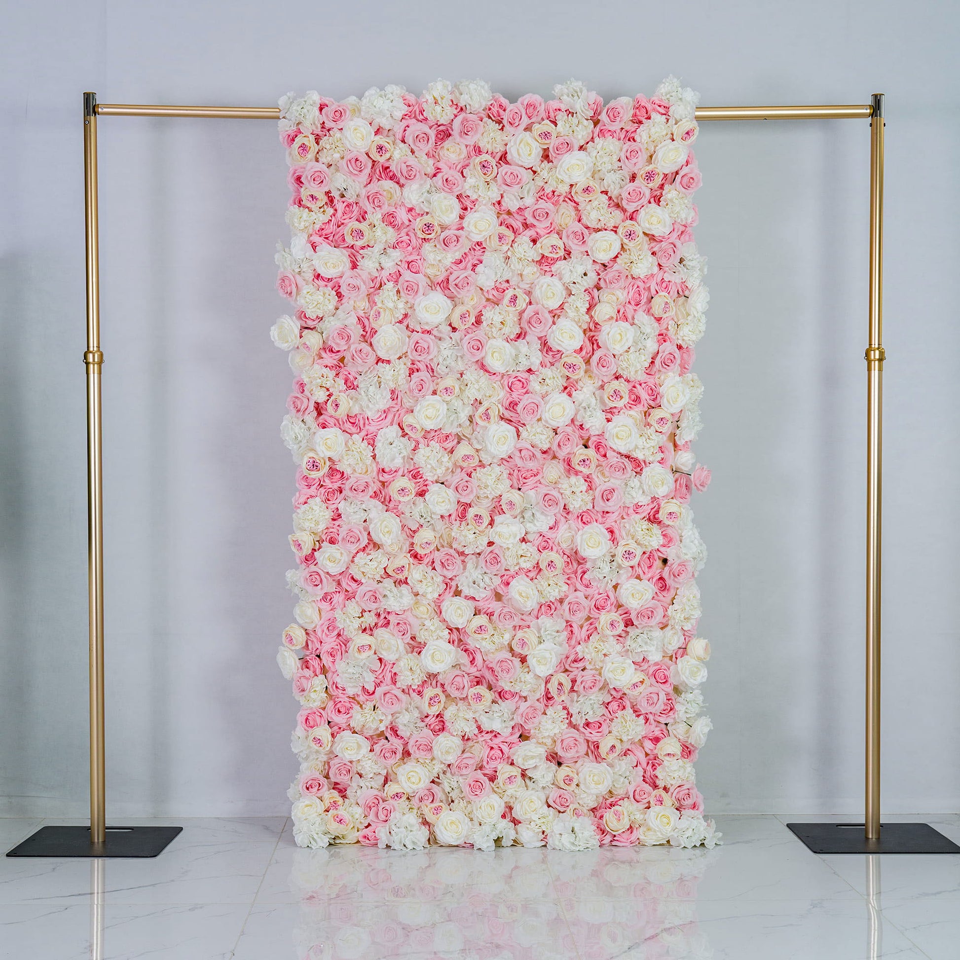 This photo features a large floral backdrop densely covered with pink and white roses, creating a soft and romantic color scheme. Mounted on a golden frame, it exudes elegance. Ideal for weddings, bridal showers, or other romantic events, its pastel hues and lush arrangement give a dreamy, sophisticated style. Size appears substantial, making a bold decorative statement. 