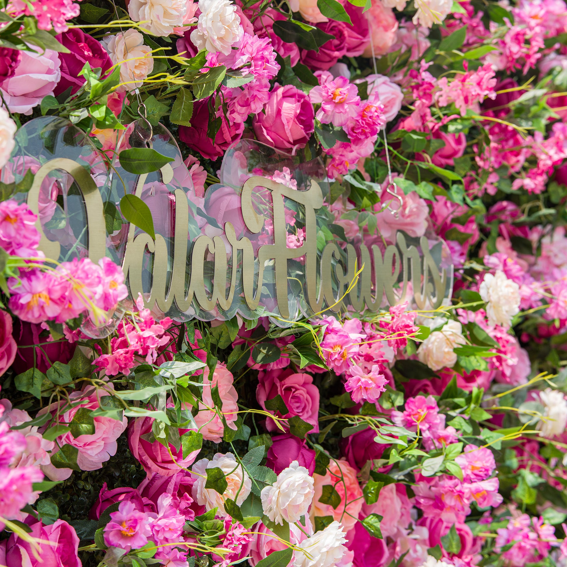 This photo showcases a dense and vibrant floral arrangement, predominantly featuring pink and white roses, along with other assorted pink flowers. The lush green foliage provides a rich backdrop. The text "ValarFlowers" in elegant golden lettering stands out on a clear background, adding a touch of sophistication. The overall scene exudes a lively and romantic atmosphere, perfect for events like garden weddings or spring - themed parties. 