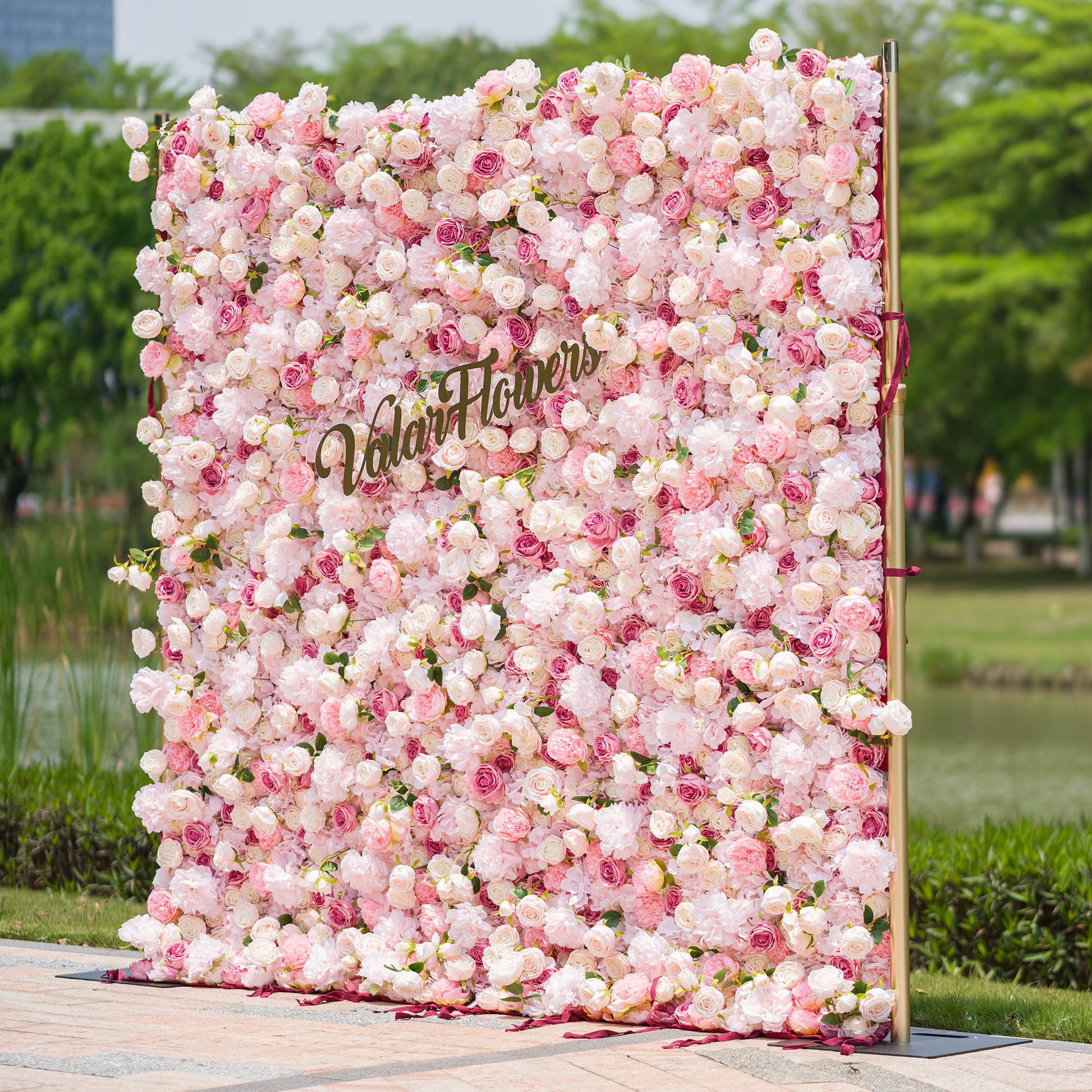 This photo from ValarFlowers features a large, opulent floral backdrop. It is densely adorned with an array of pink and white roses and peonies, creating a soft and romantic aesthetic. The backdrop is framed by metallic poles, adding a touch of modern elegance. Ideal for weddings, bridal showers, or a “Romantic Blush” - themed event, it serves as a beautiful and eye - catching decorative element, exuding charm and grace. 