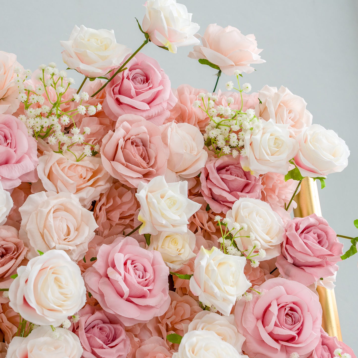 This photo brims with an assortment of roses in soft hues of pink, peach, and white, interspersed with delicate sprigs of baby's breath. The gentle pastel palette and lush arrangement make it perfect for romantic occasions like weddings, bridal showers, or anniversary celebrations. It aligns seamlessly with event themes centered around love, elegance, and tenderness, creating a dreamy and inviting atmosphere. 