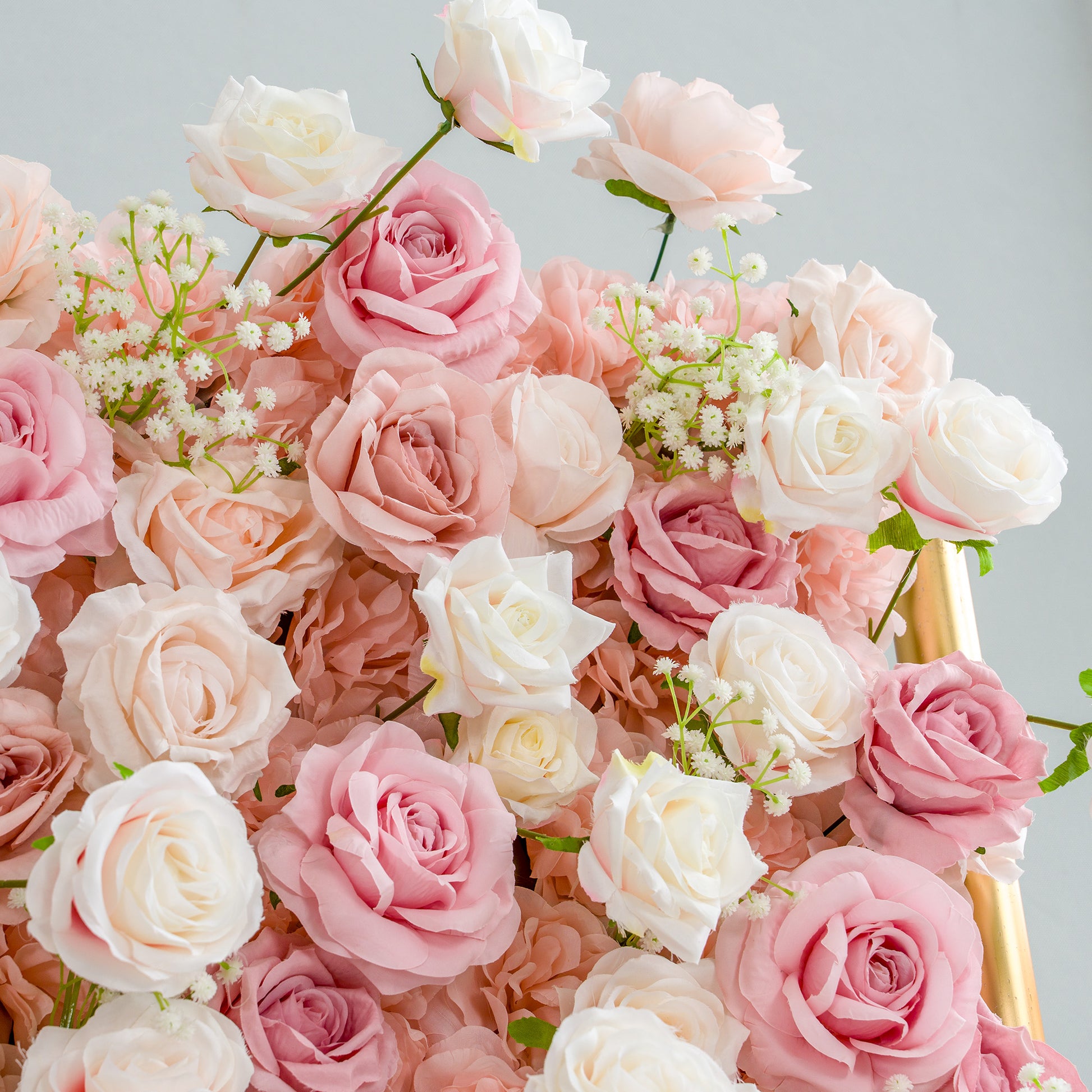 This photo brims with an assortment of roses in soft hues of pink, peach, and white, interspersed with delicate sprigs of baby's breath. The gentle pastel palette and lush arrangement make it perfect for romantic occasions like weddings, bridal showers, or anniversary celebrations. It aligns seamlessly with event themes centered around love, elegance, and tenderness, creating a dreamy and inviting atmosphere. 