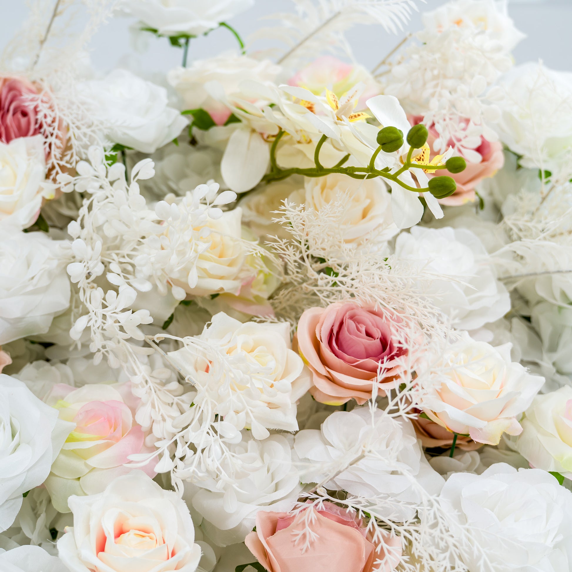 This photo showcases a lush floral arrangement with white roses, some with pinkish - hued edges, and white orchids, complemented by delicate white foliage. The soft pastel color palette creates an elegant and serene atmosphere. Ideal for weddings or upscale events, it exudes a refined, dreamy style. 