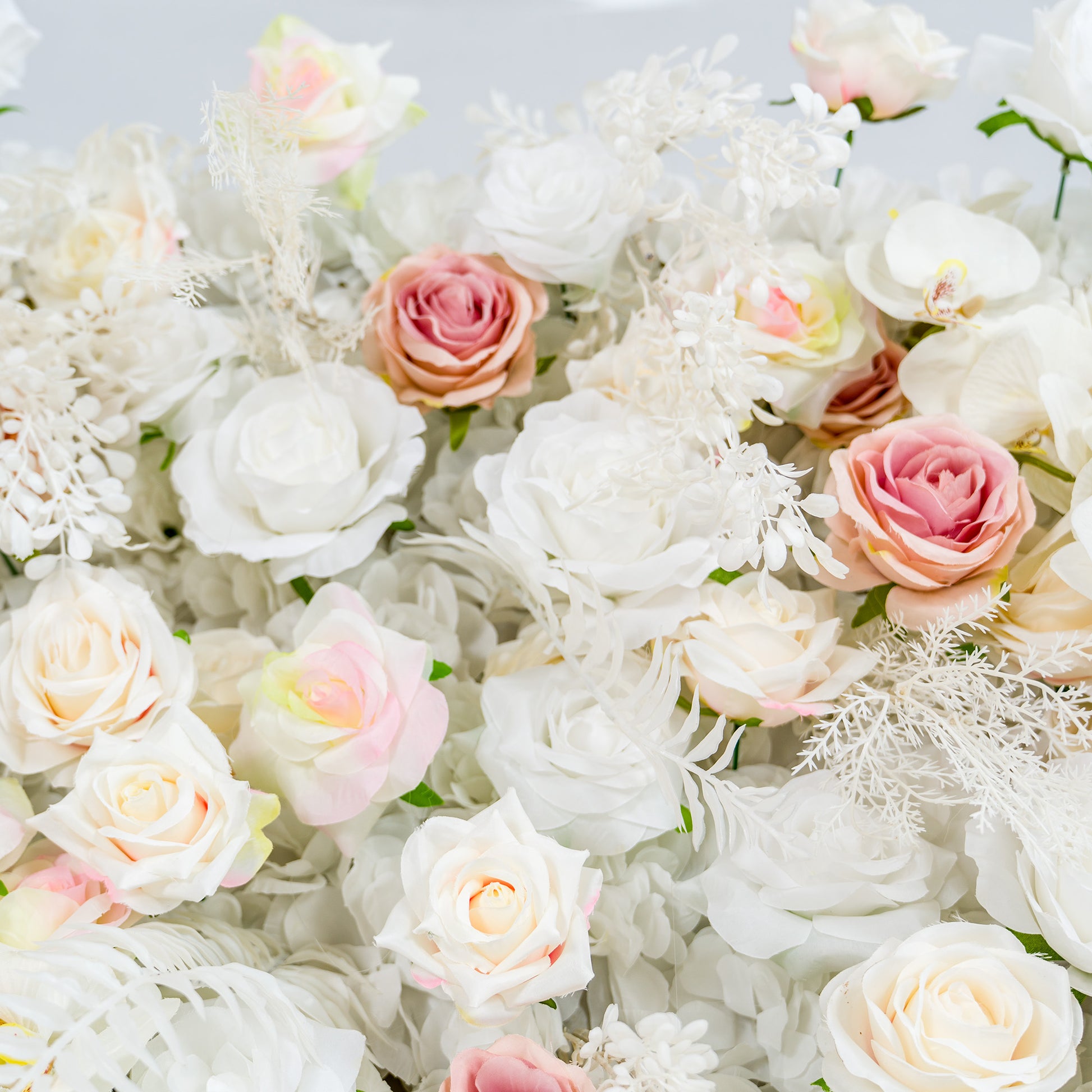 This photo features a lush floral arrangement with white roses and pink - tinted roses, complemented by white foliage and white orchids. The soft pastel color palette of white and light pink creates an elegant and romantic atmosphere. Ideal for weddings or upscale events, it exudes a refined, dreamy style. 